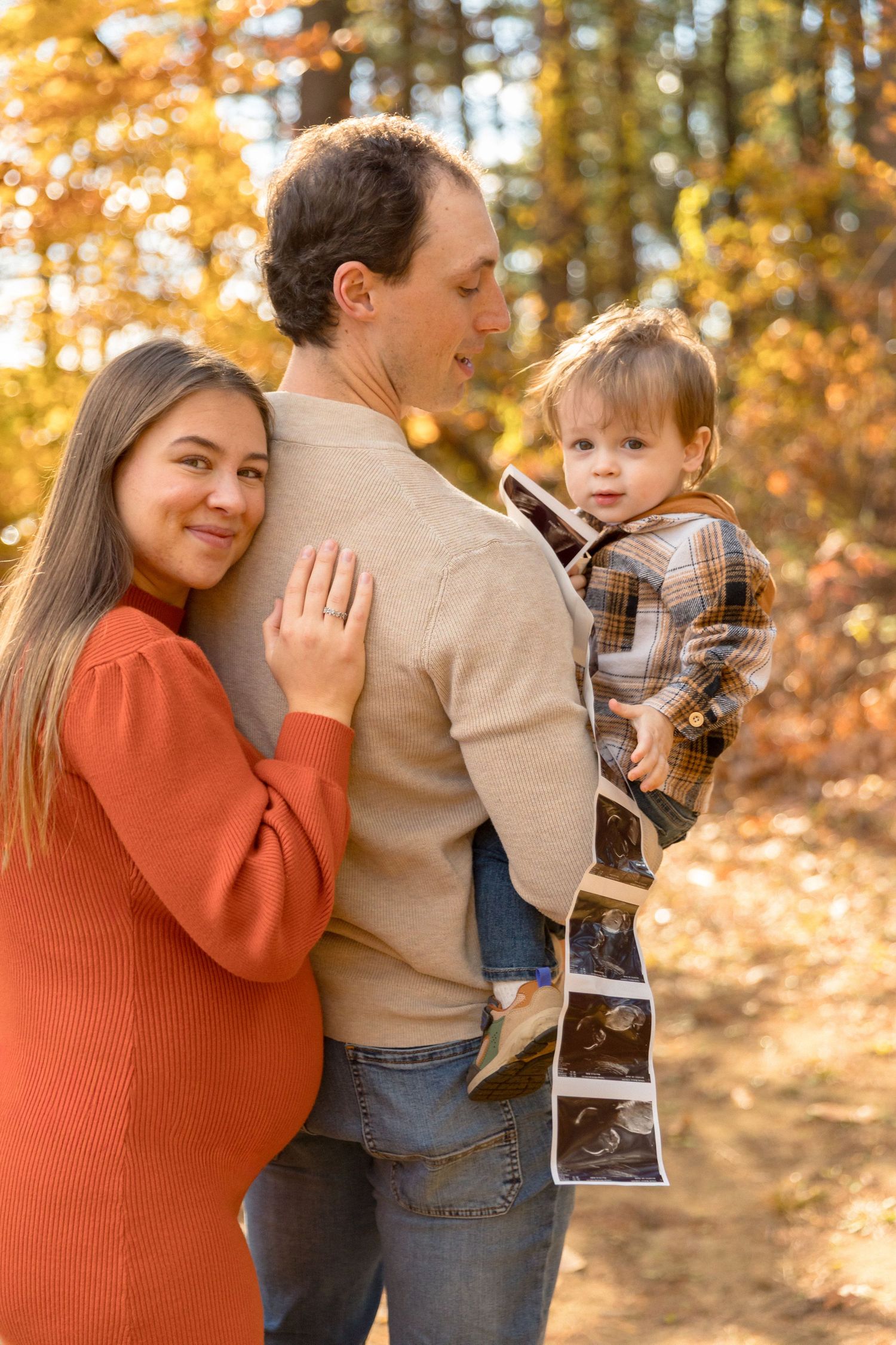 Family sharing joyful moments together in fall forest setting.