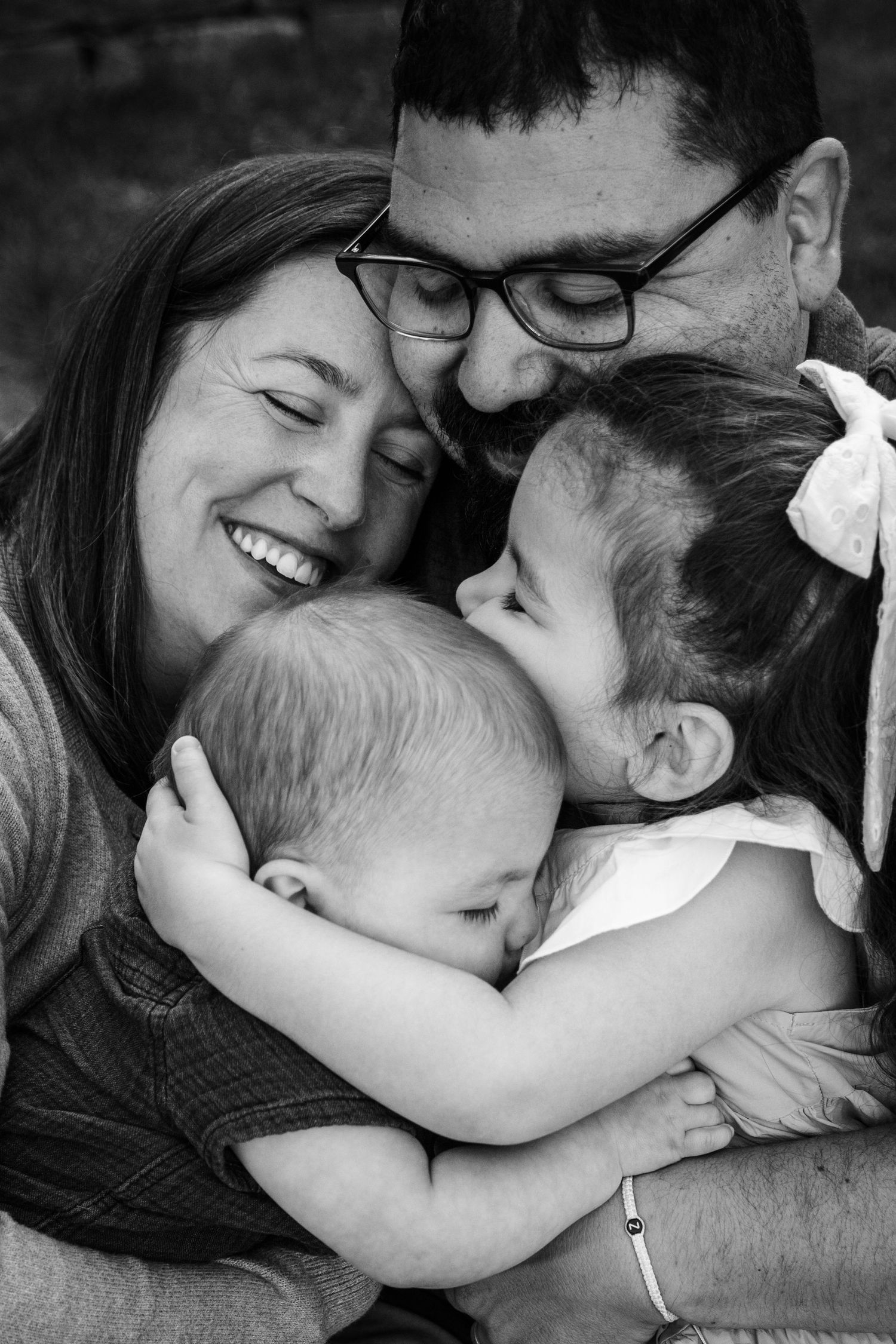 Black and white intimate family portrait showing tender moments together.