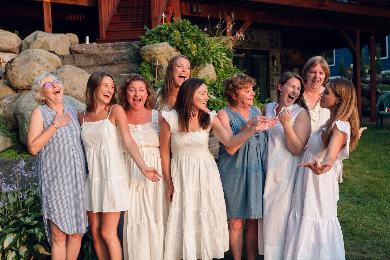 A group photo of people wearing coordinated light-colored summer outfits.