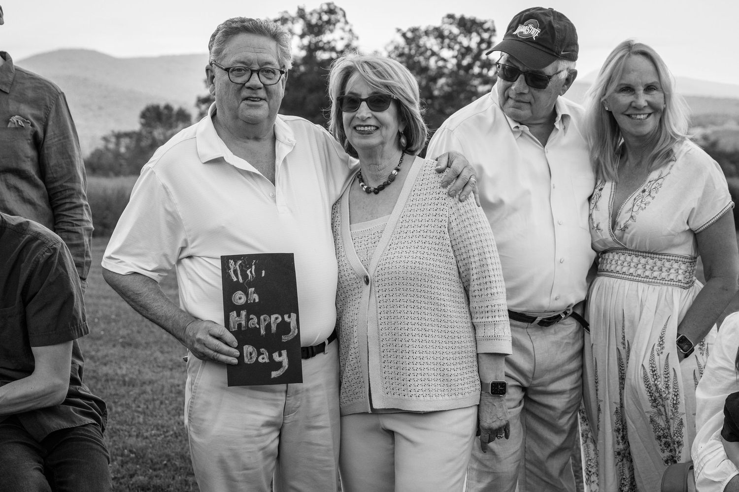 A group of people gathered outdoors holding a book in black and white photography.