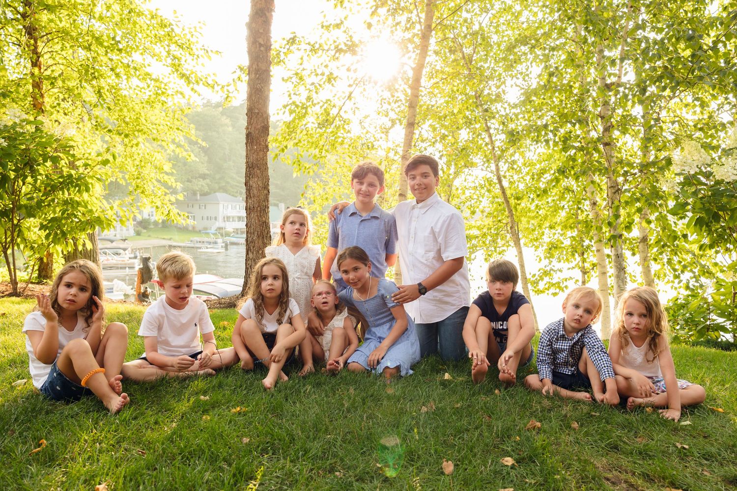 Family members lounging on grass for casual group photos during a summer gathering.