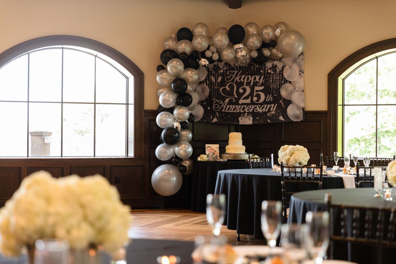 Elegant banquet hall decorated with black and white balloons for a formal event.