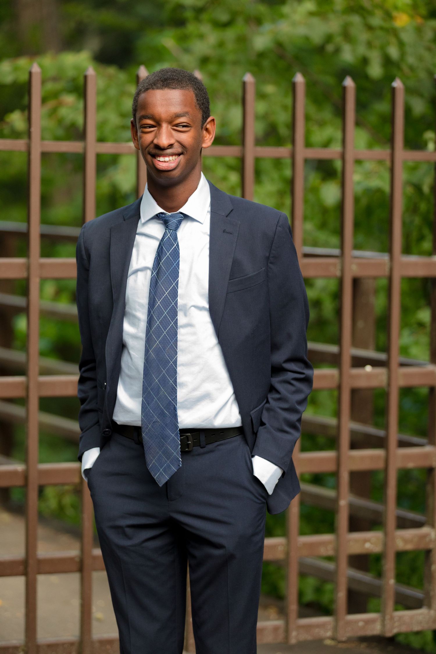 Professional outdoor portrait with wooden stairs and railing in background.