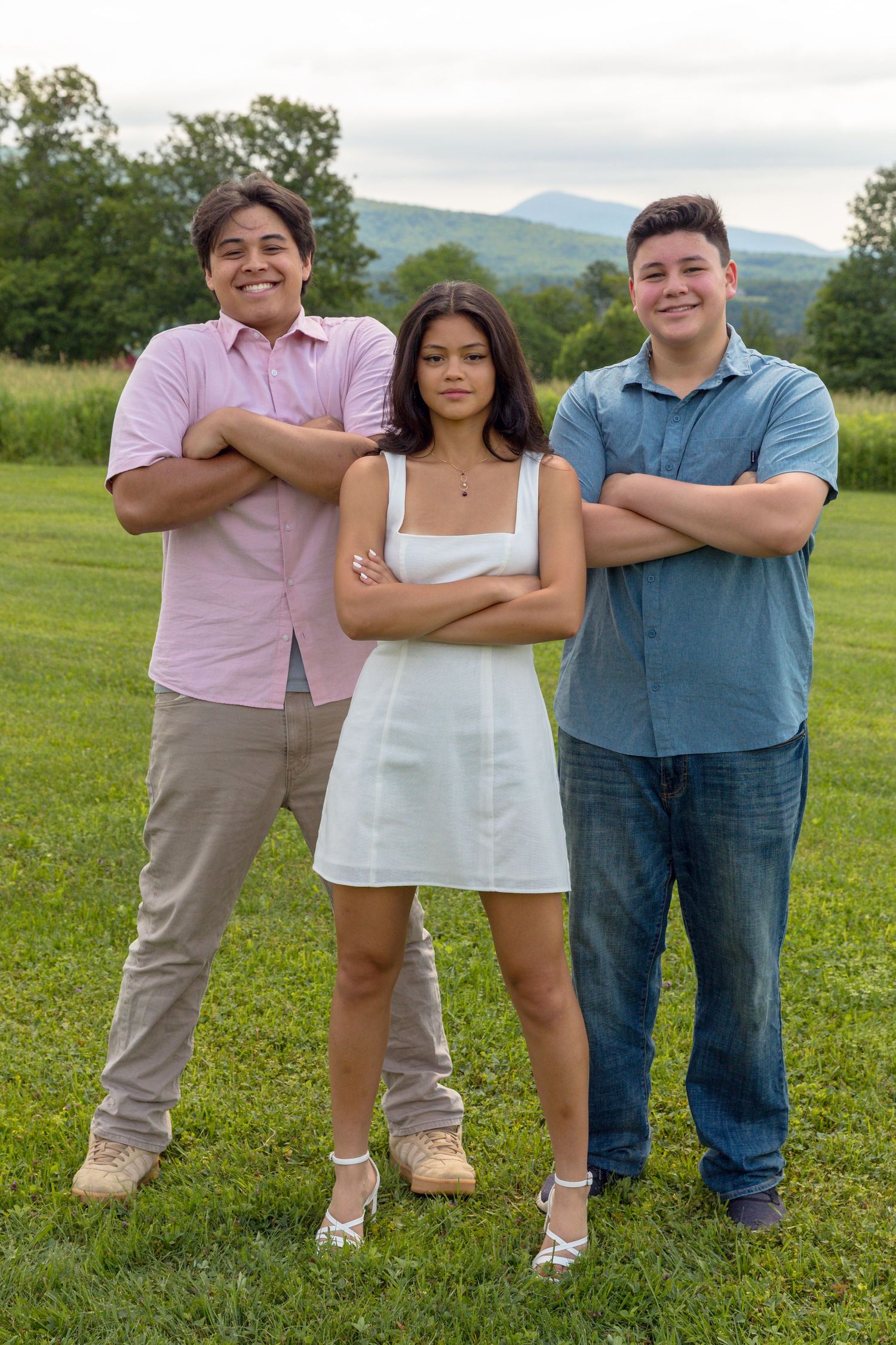 Casual outdoor family photo with members posed casually in a grassy field.