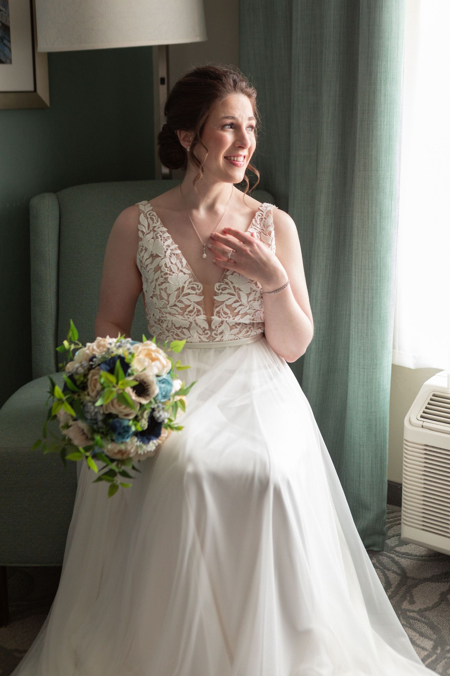 An elegant wedding dress with lace details and a flowing white skirt in natural window light.