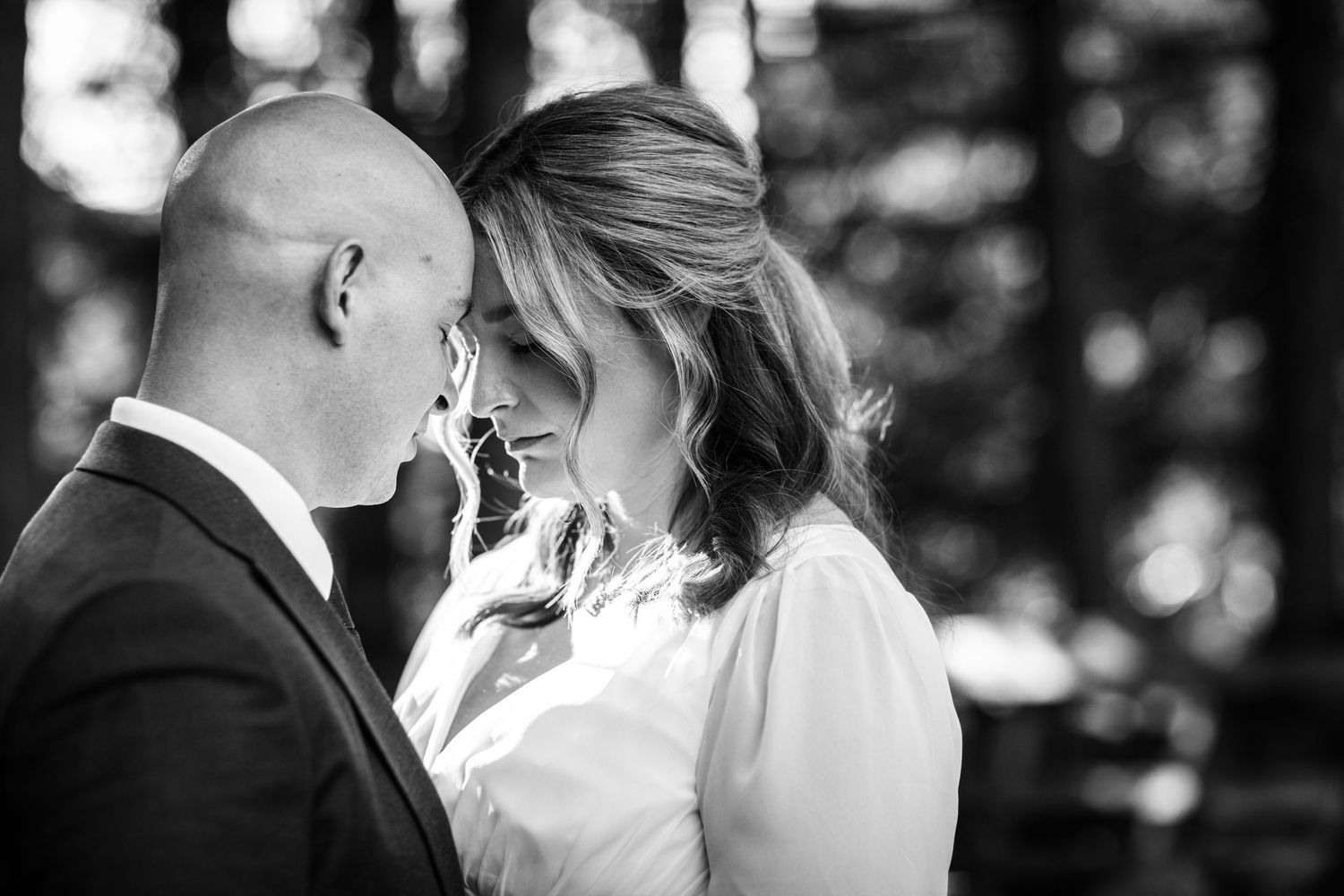 A romantic black and white wedding photo series showing intimate moments between newlyweds.