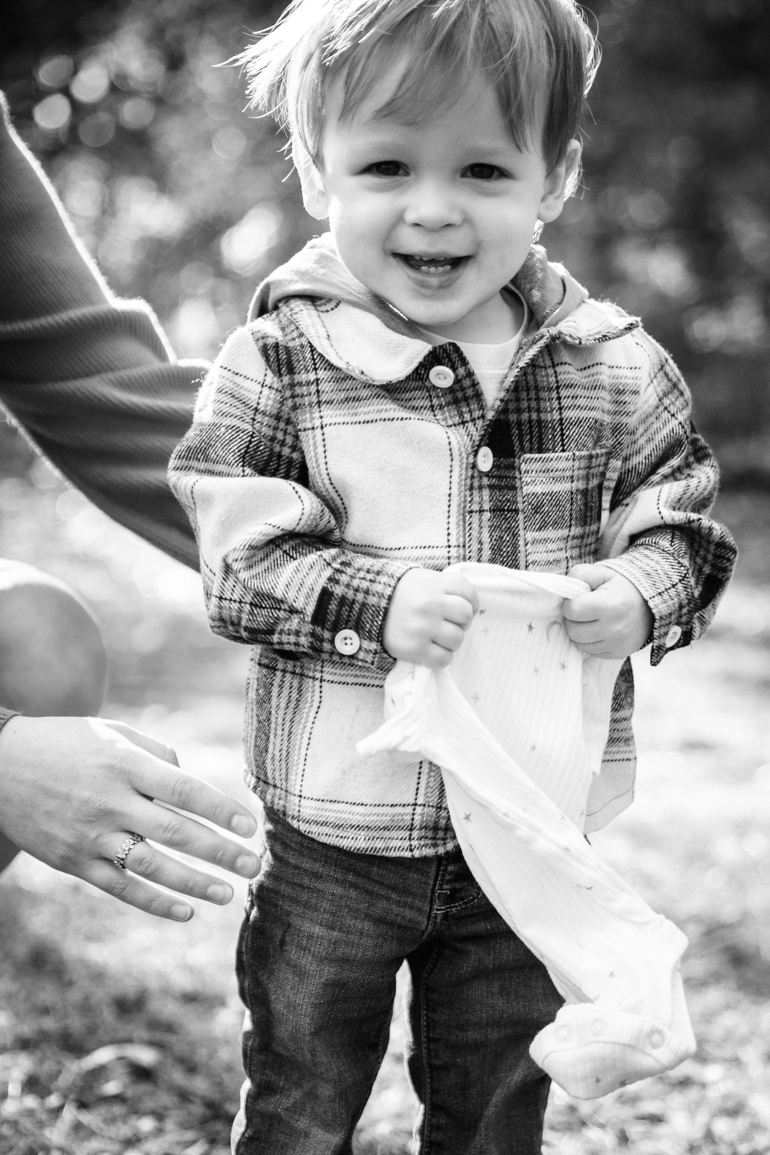 Black and white sequence of toddler playing with tissue paper outdoors.