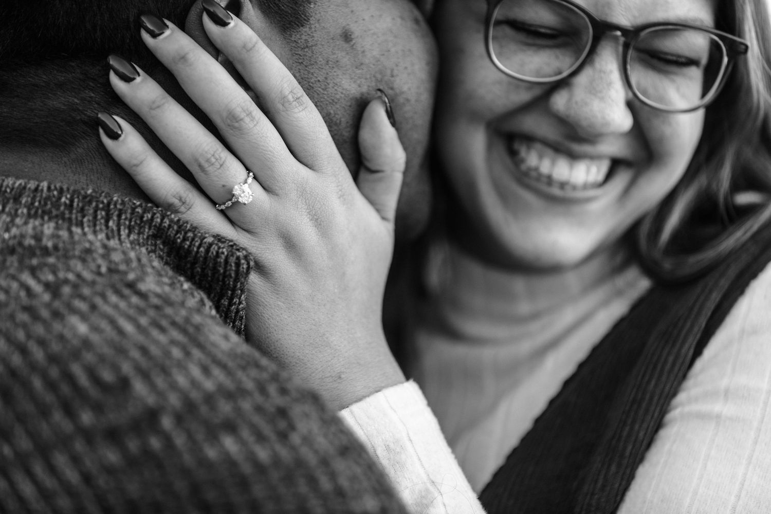 Close up black and white shot showing hands and smiling expressions.