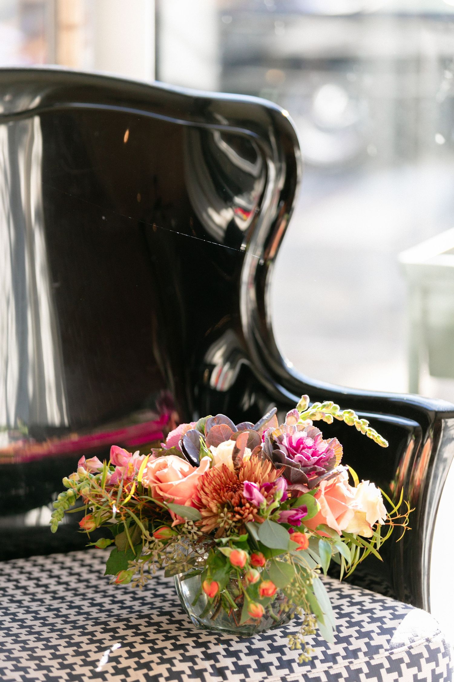 Colorful floral centerpieces with pink and peach blooms arranged on a checkered tablecloth.