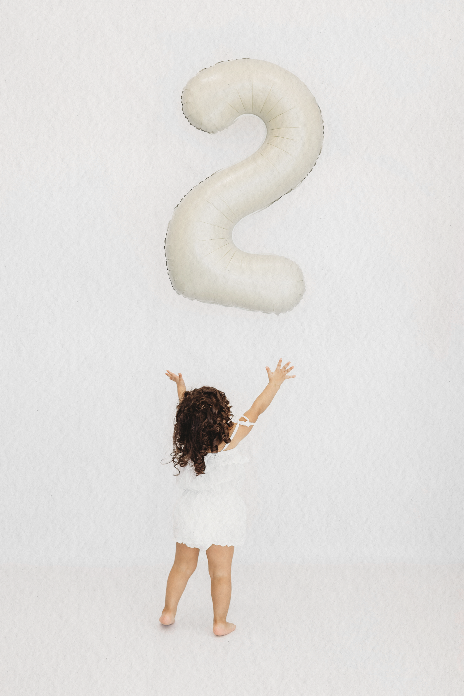 Baby reaching for a number one balloon at their first birthday session in Dbayeh, Lebanon