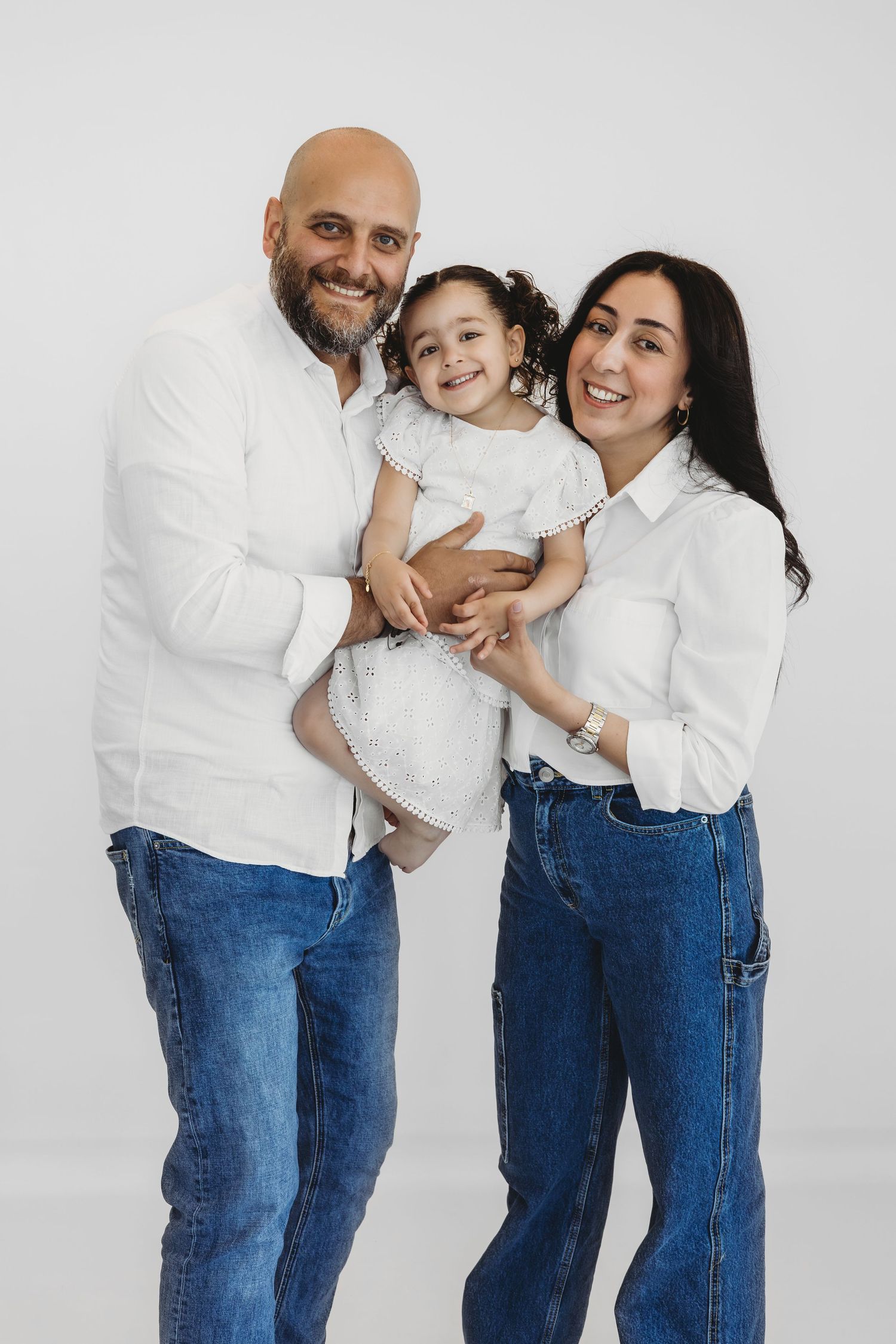 Family of three with their baby during a warm studio photoshoot in Dbayeh, Lebanon