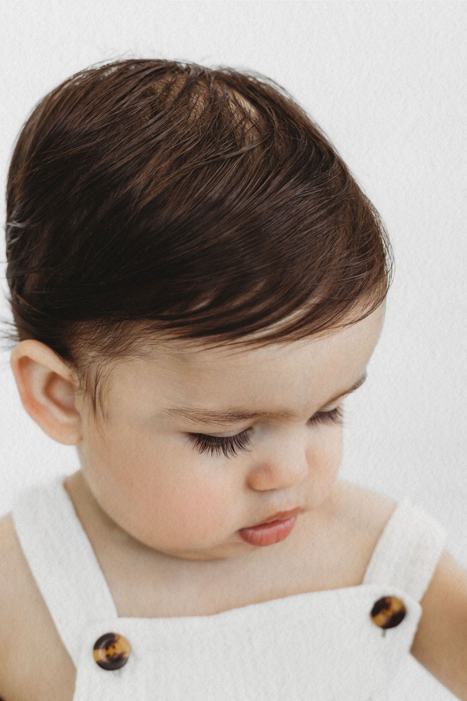 Baby boy in a white outfit during a milestone photoshoot by Dounia Raphael Photography in Dbayeh, Lebanon