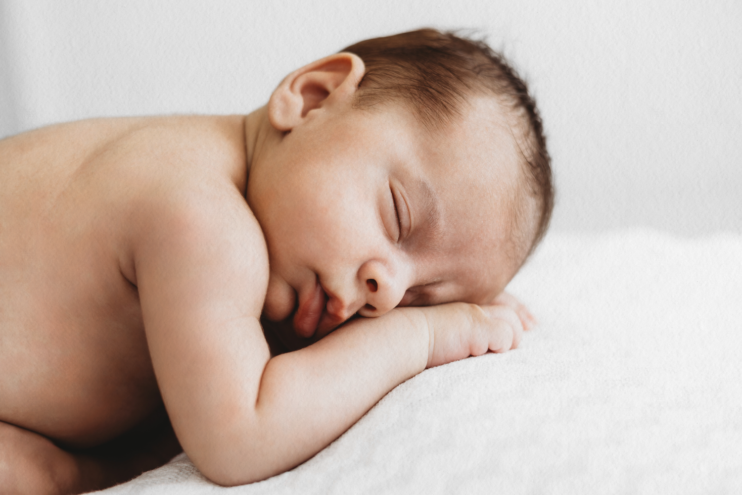 Peaceful sleeping newborn during a gentle newborn photoshoot by Dounia Raphael Photography