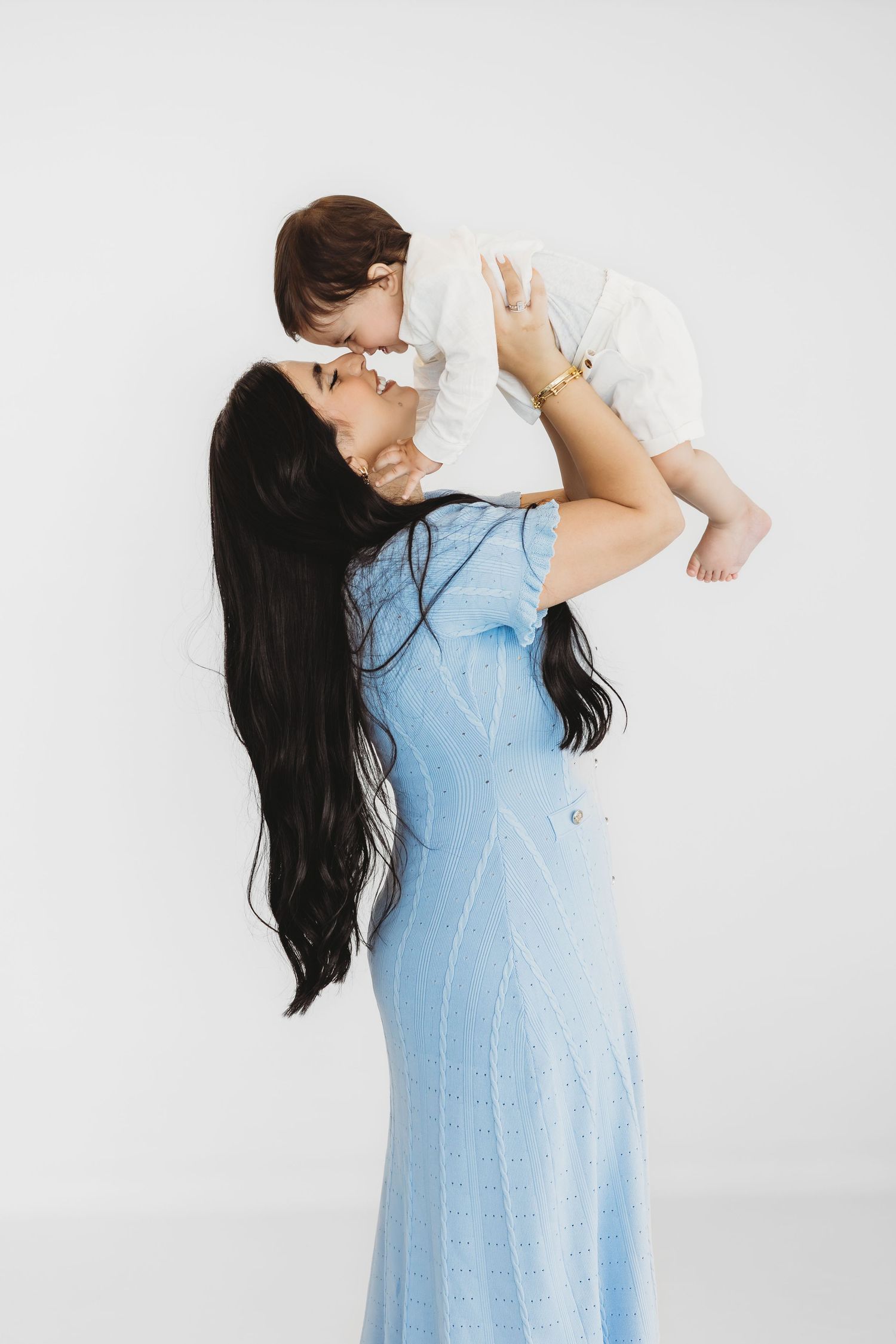 Mother in a blue dress holding her baby during a family session by Dounia Raphael Photography