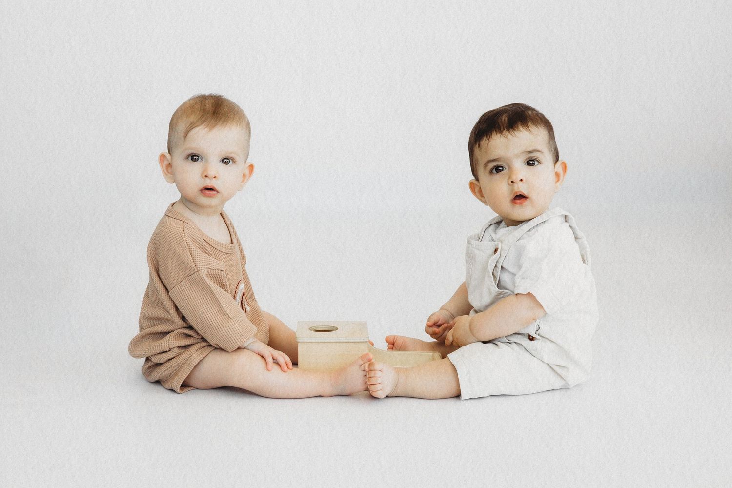 Two babies sitting together during a studio session by Dounia Raphael Photography in Dbayeh, Lebanon