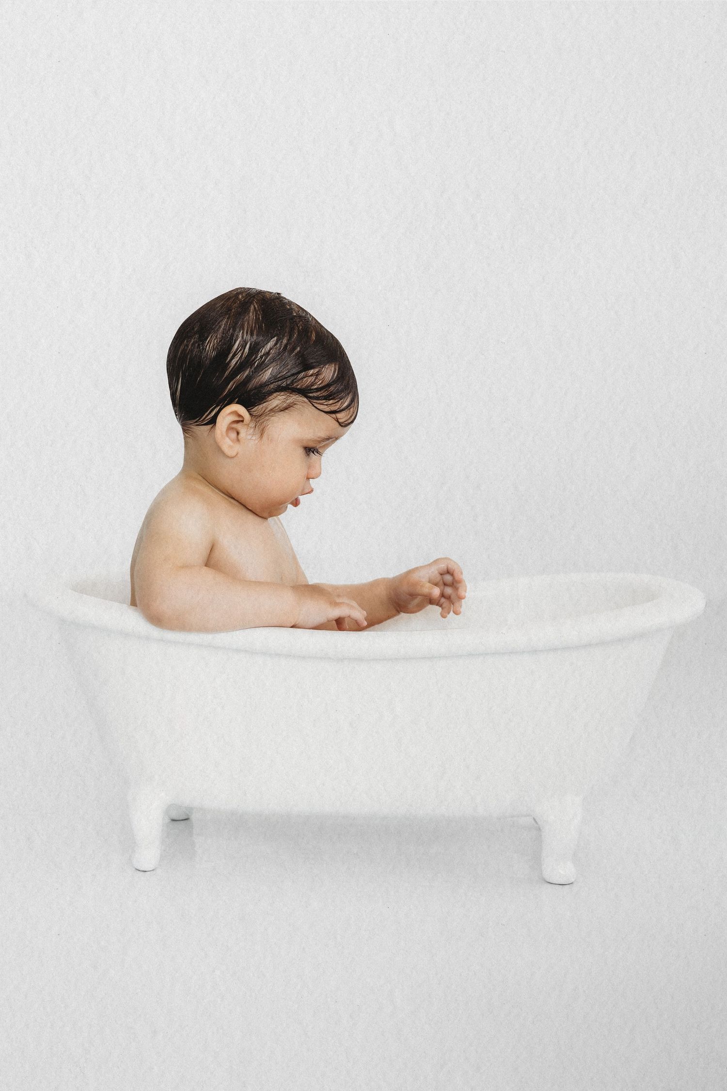Baby enjoying a bubble bath session in a vintage tub in Dbayeh, Lebanon