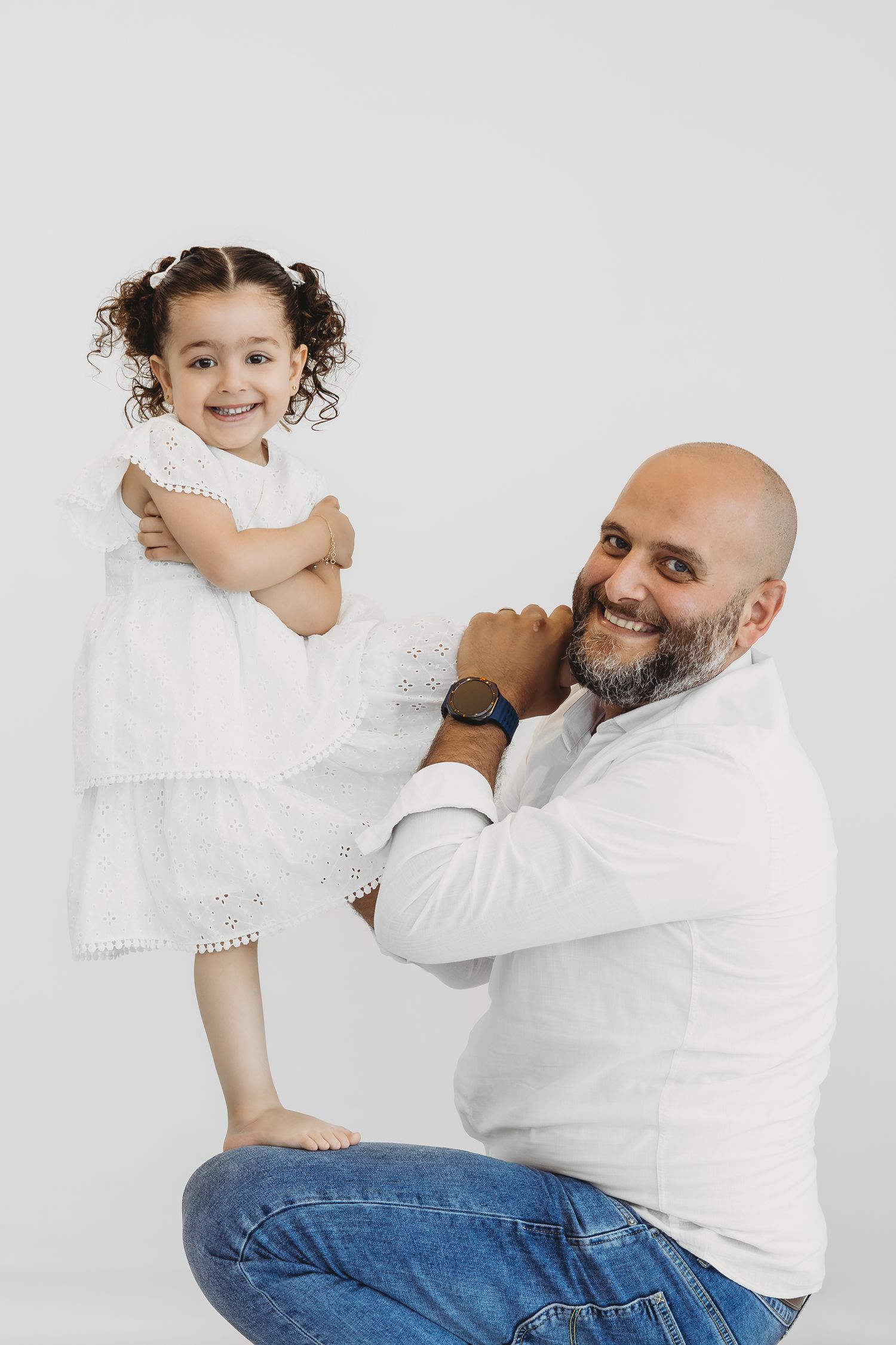 Warm, candid family photoshoot in a white studio by Dounia Raphael Photography