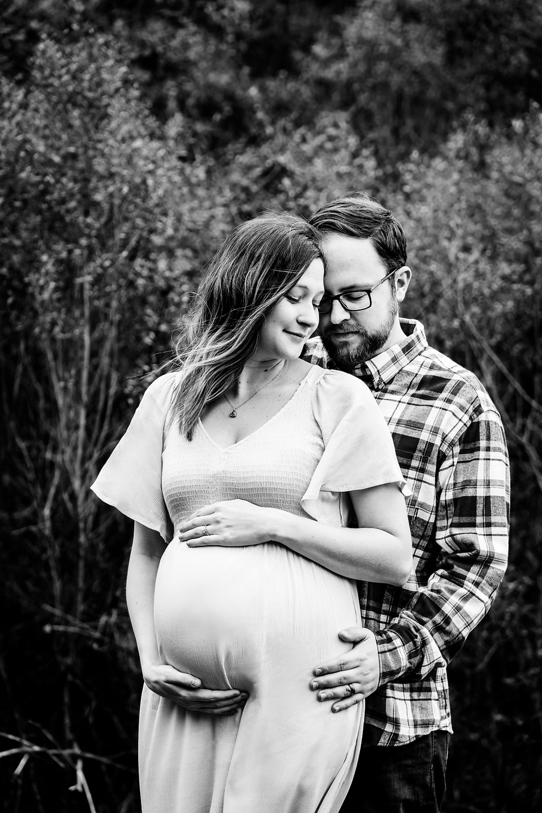Mom to be cradling her belly as Dad cuddles into her during a Lexington SC winter Maternity Portrait Session.
