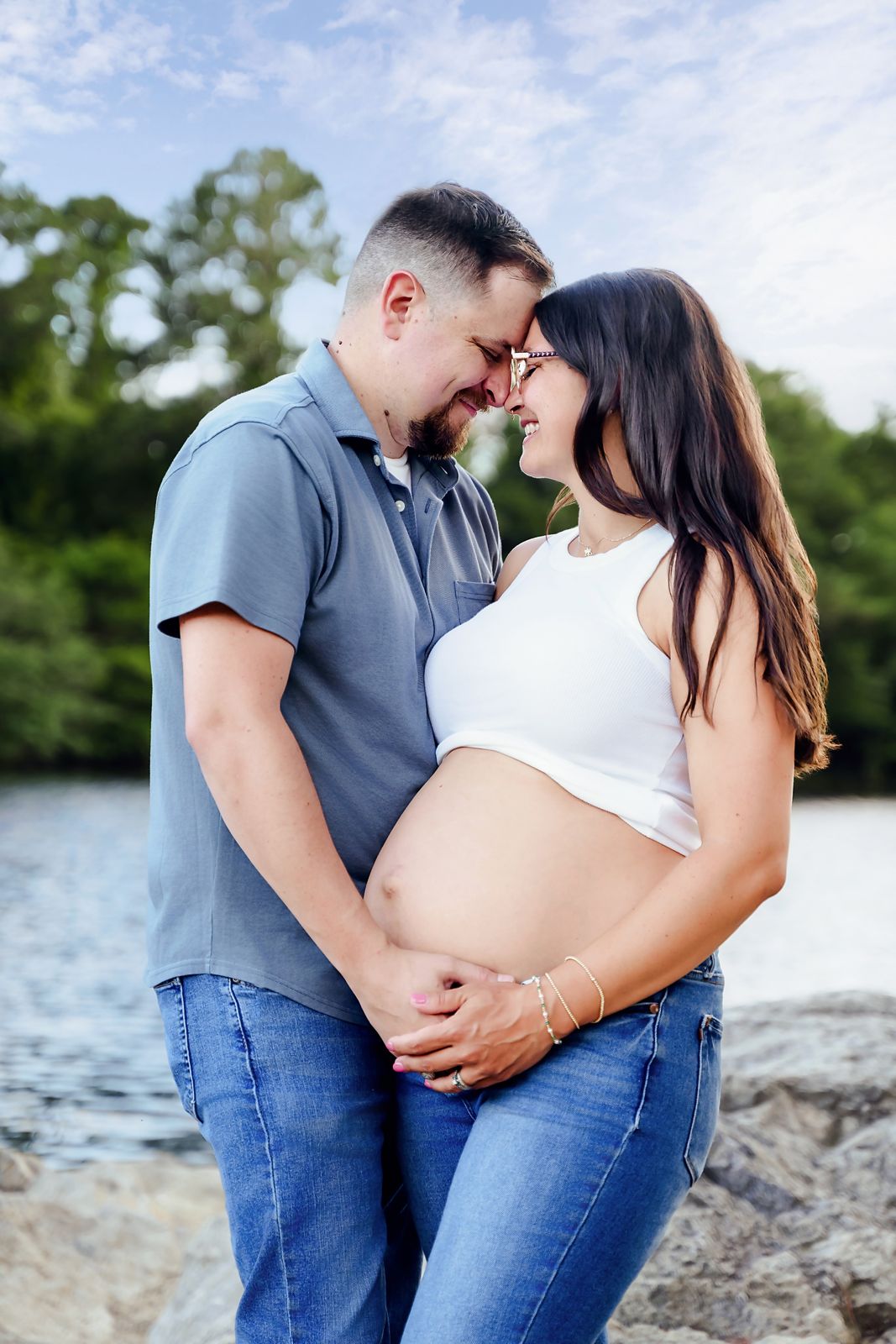 Lexington SC outdoor maternity portrait of a mom and dad to be embracing so that they create a heart shape with moms belly showing.