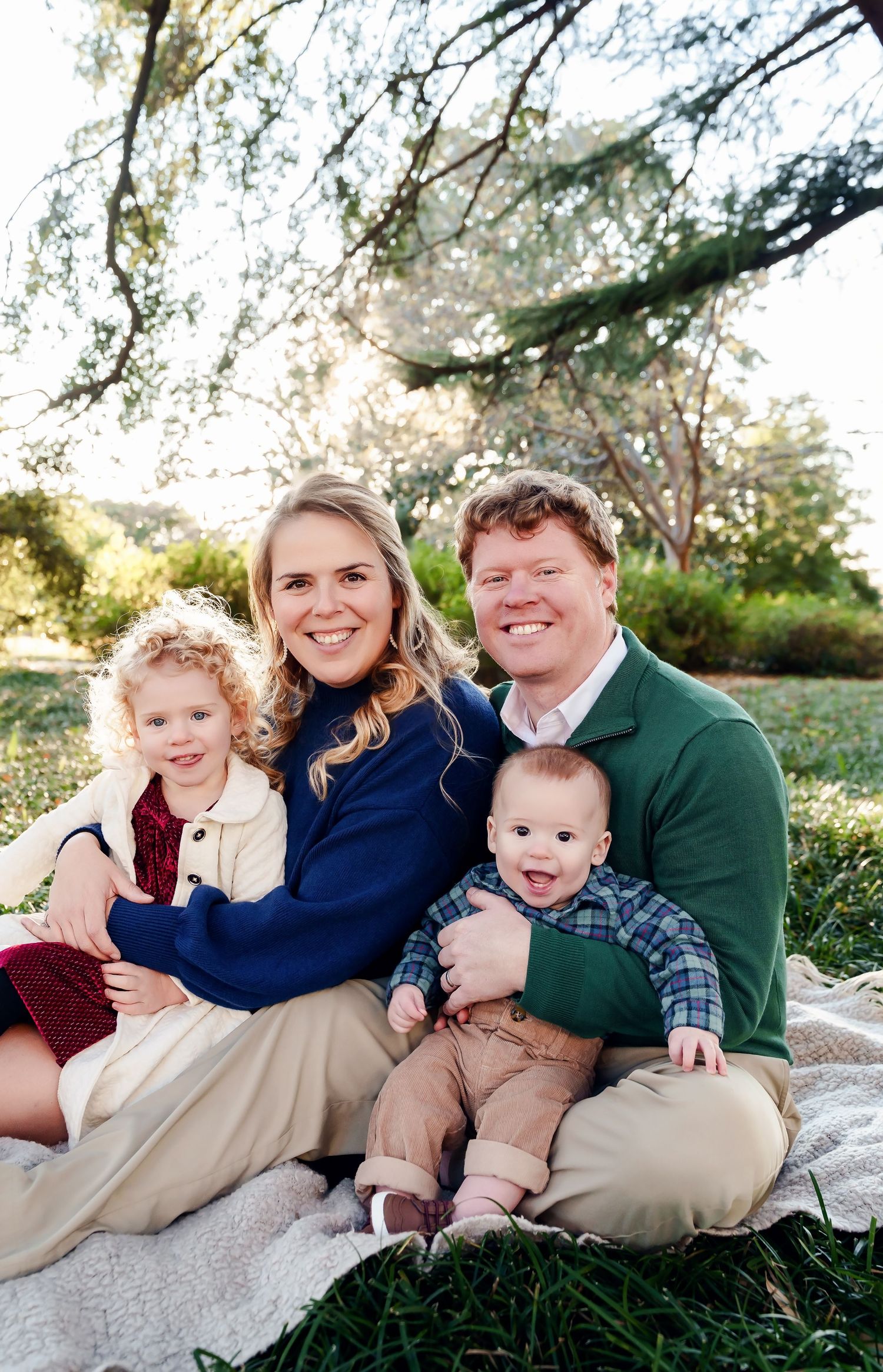 Gorgeous family of four all cuddled in together while smiling at the camera during a Columbia SC Family Portrait Session.