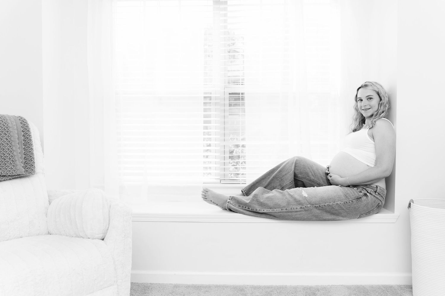 Mom to be sitting on a window bench with her baby bump showing during a greater Columbia SC in-home Maternity Session.