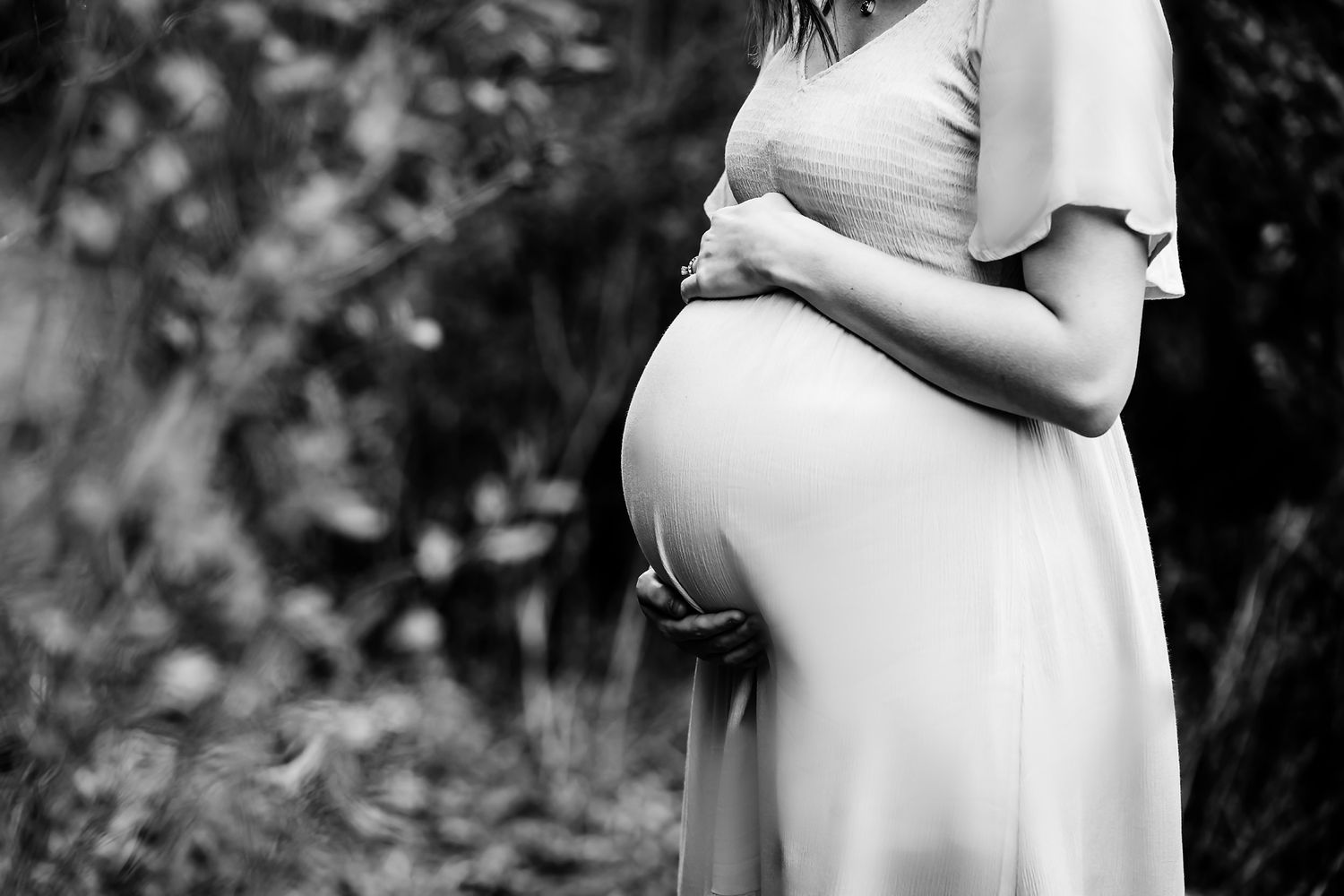 Stunning fine art black and white close up of Mom to be cradling her belly during a Columbia SC outdoor maternity portrait session.
