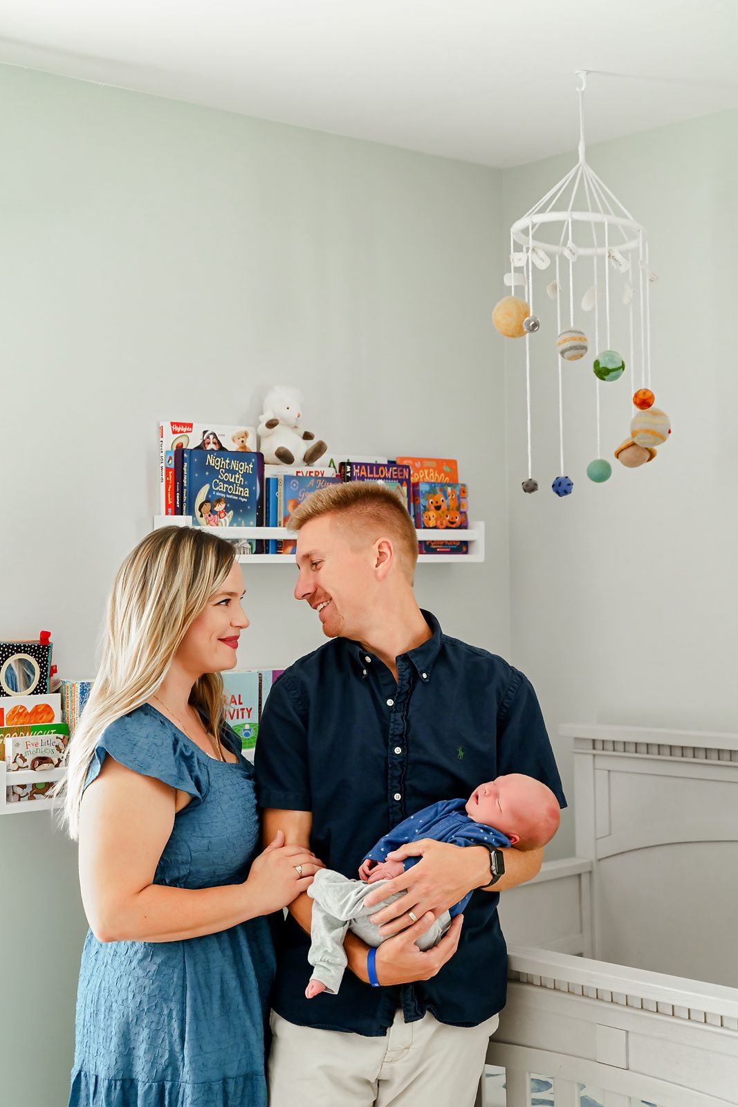 Mom and Dad posing with their Newborn Baby Boy in his nursery during a Chapin SC in-home newborn photography session.