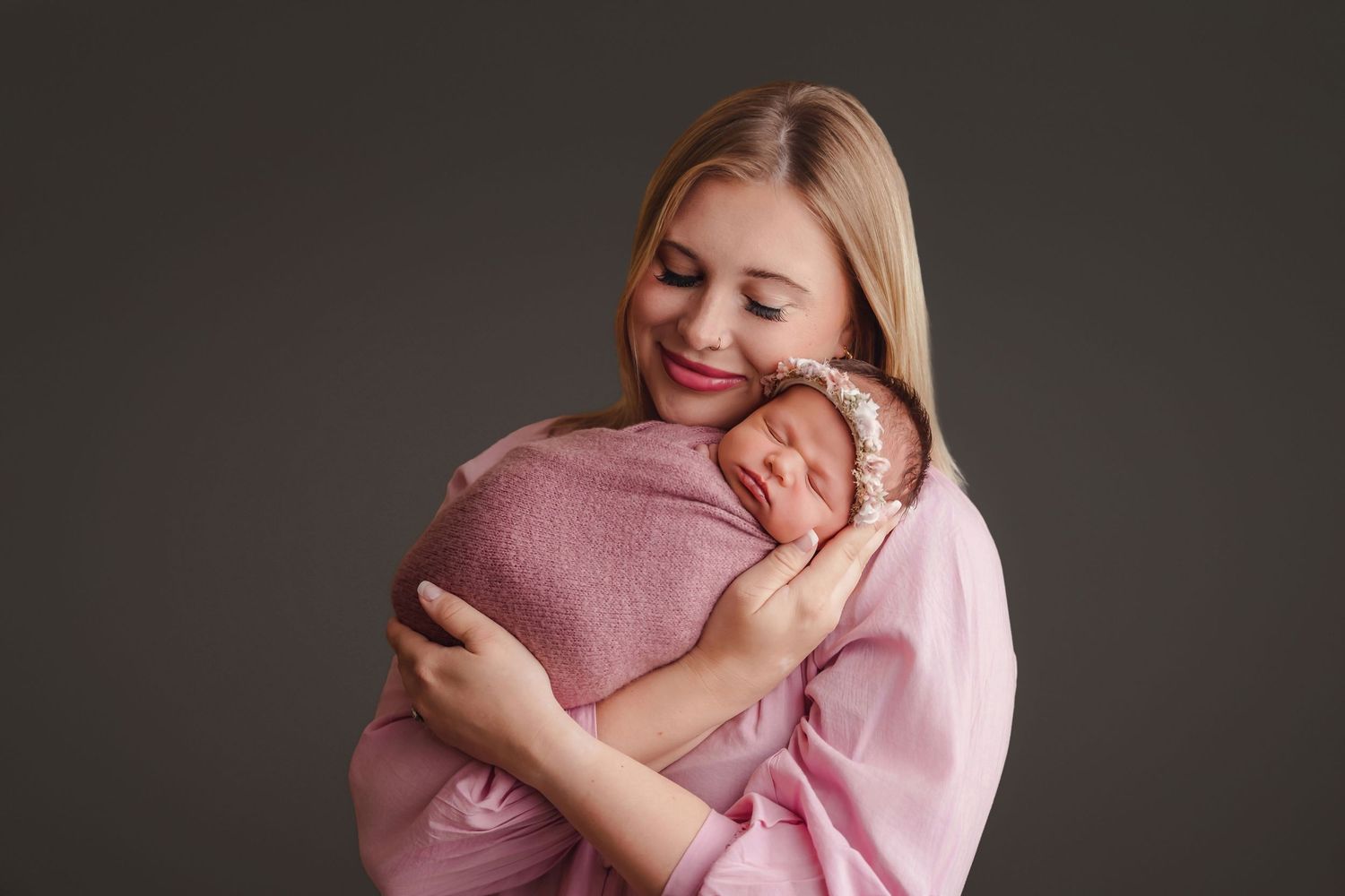 Mom snuggling her swaddled newborn close during a Chapin SC Studio Newborn Portrait Session.