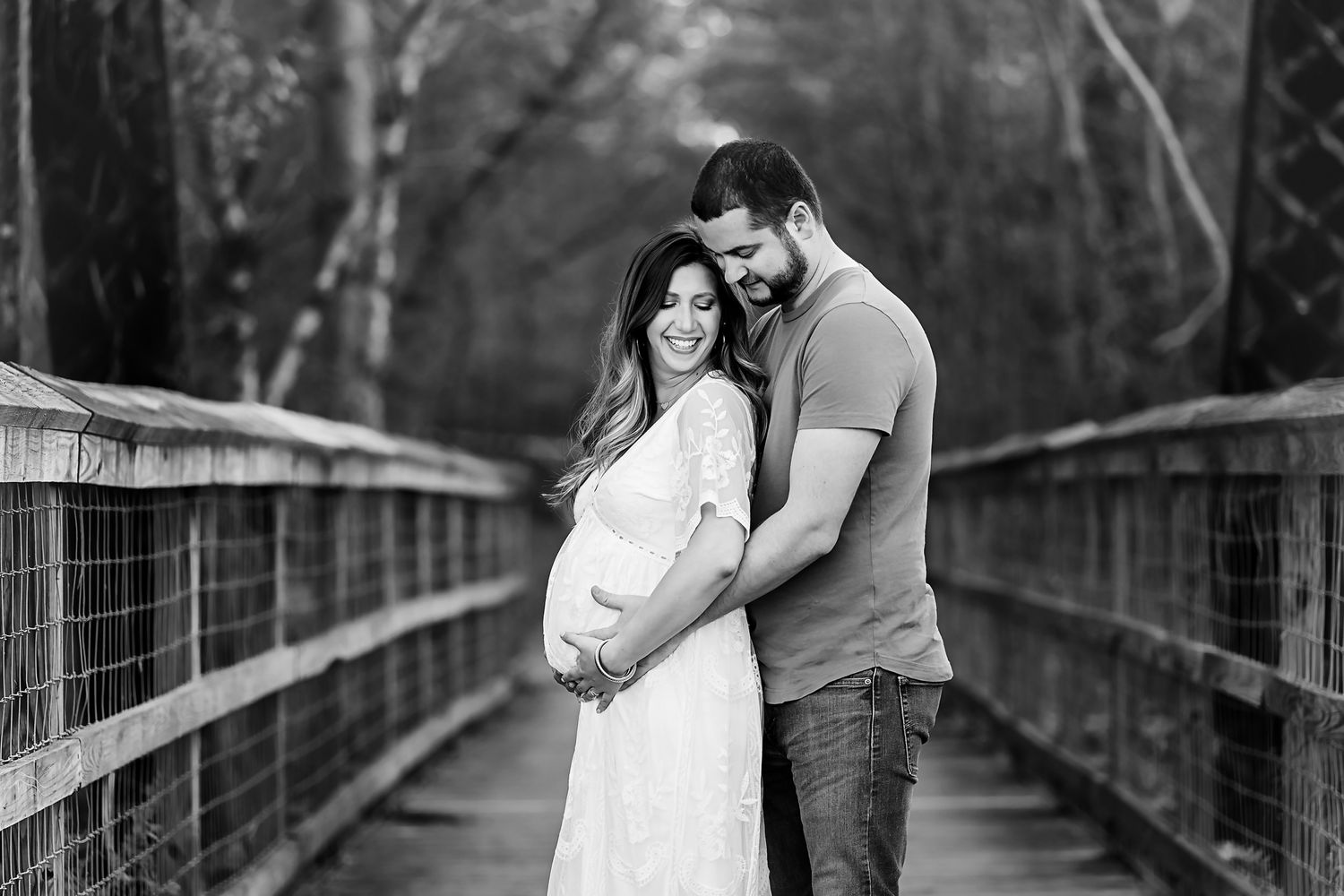 Black and White maternity portrait of mom and dad to be framed by the Palmetto Trail Trestle in Peak SC.