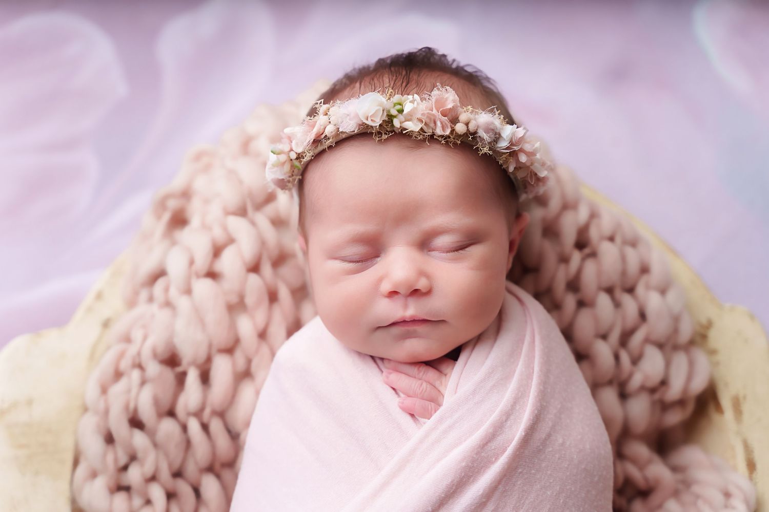 Simple and sweet studio newborn portrait, baby swaddled and posed simply in a prop during a Chapin SC session.