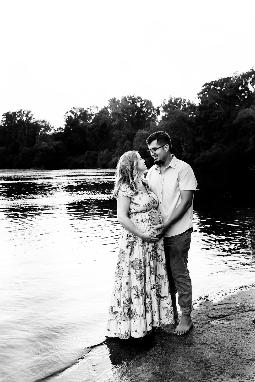Black and white maternity image of a couple posing while standing on the waters edge during a Columbia SC Maternity Portrait Session.