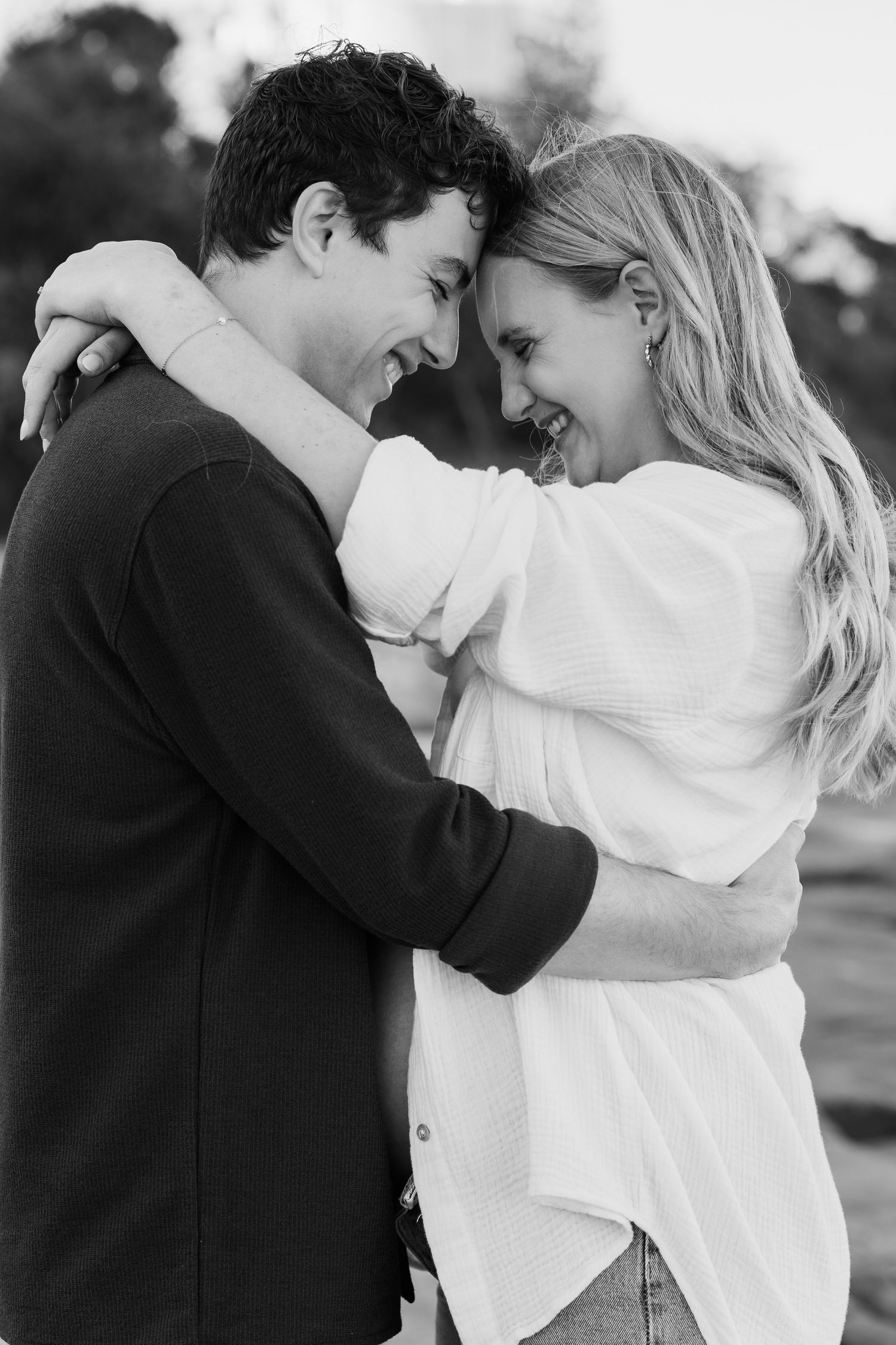 Brisbane maternity photographer — black and white portrait of couple sharing a tender kiss, man embracing expectant mother in a romantic out
