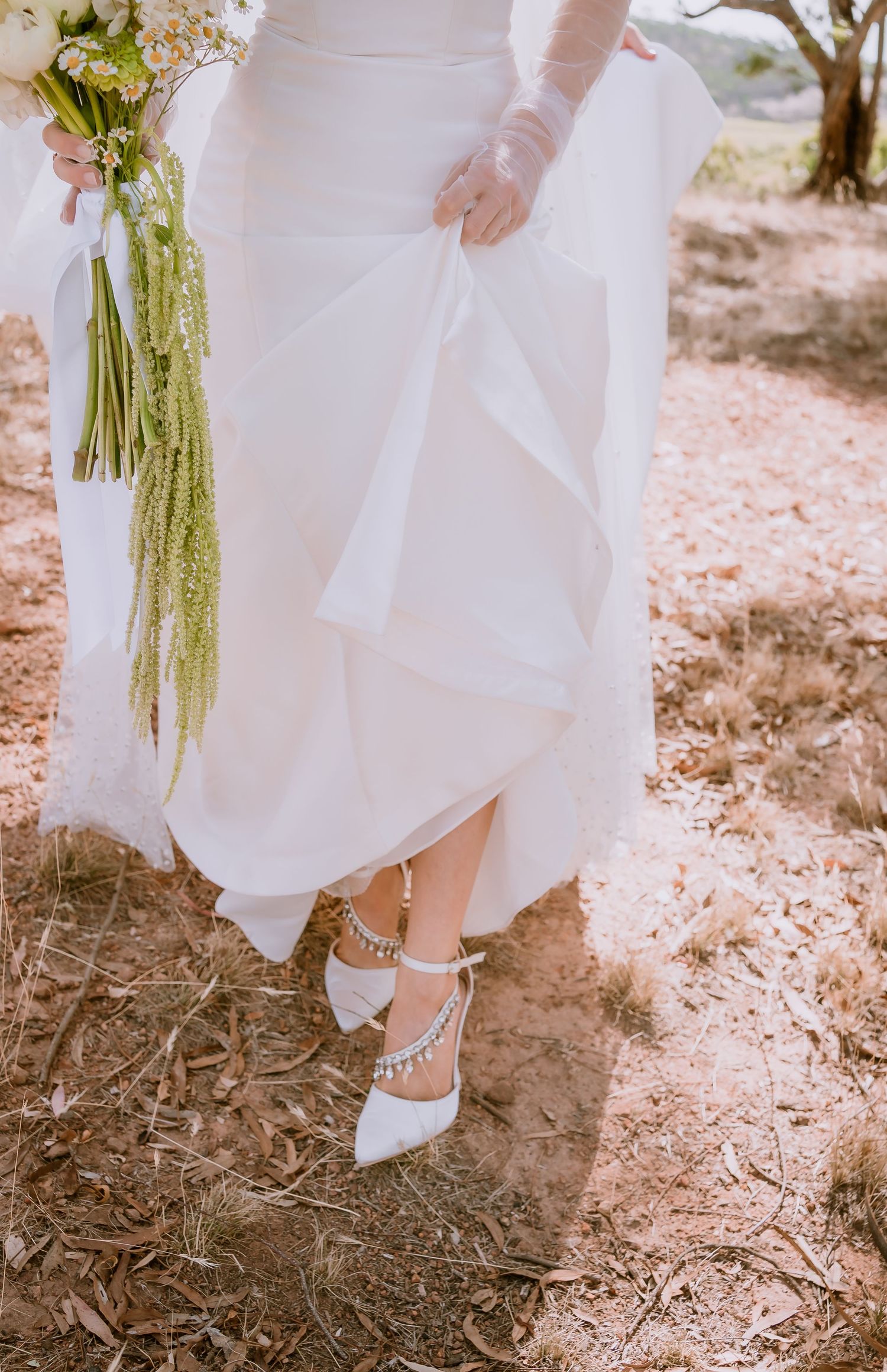 Brisbane wedding photographer — detail shot of bride's veil falling over autumn leaves on the ground, beautiful and artistic wedding day det