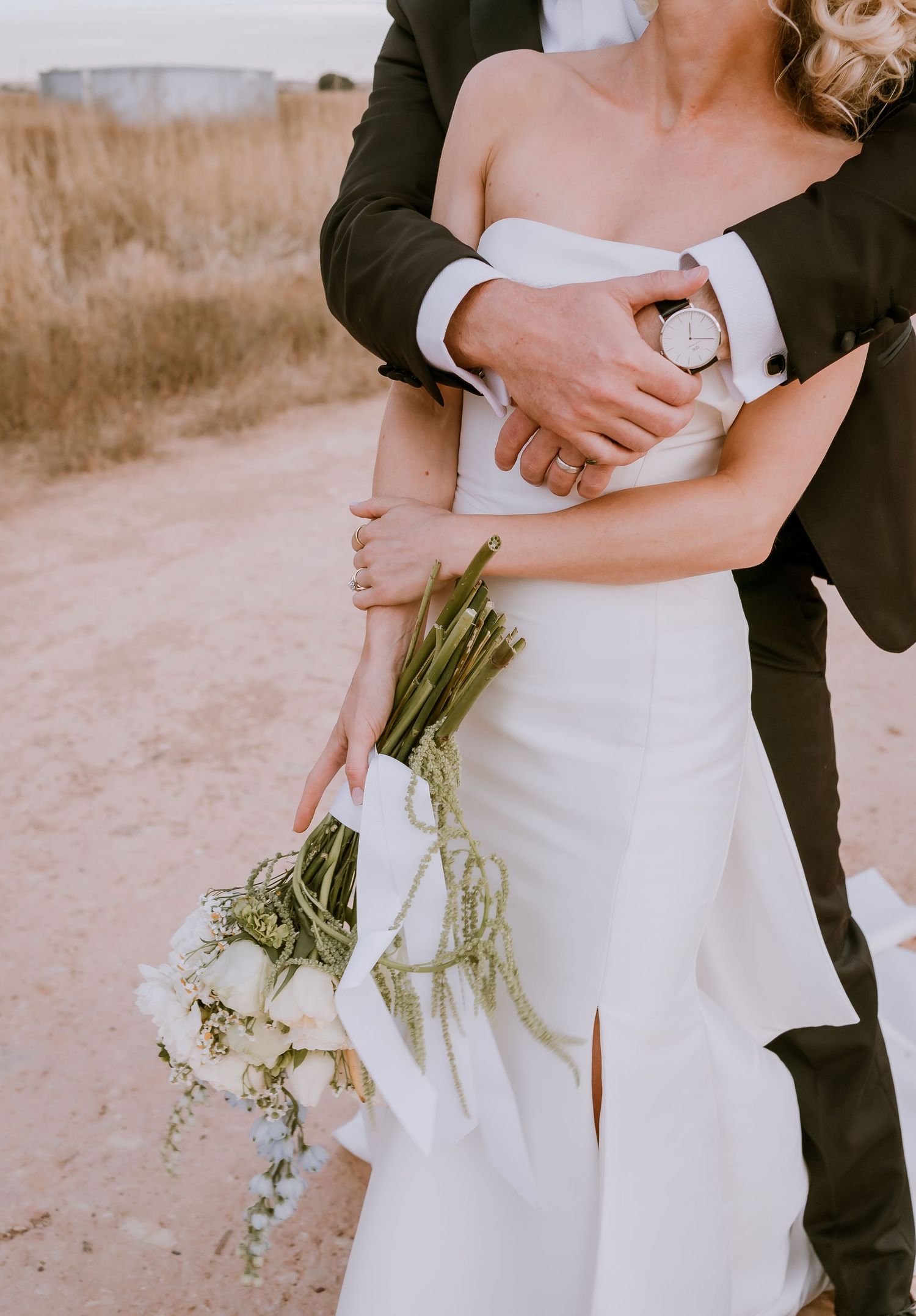 Brisbane wedding photographer — groom embracing bride from behind while she holds her bouquet, intimate and loving wedding portrait by Joy F