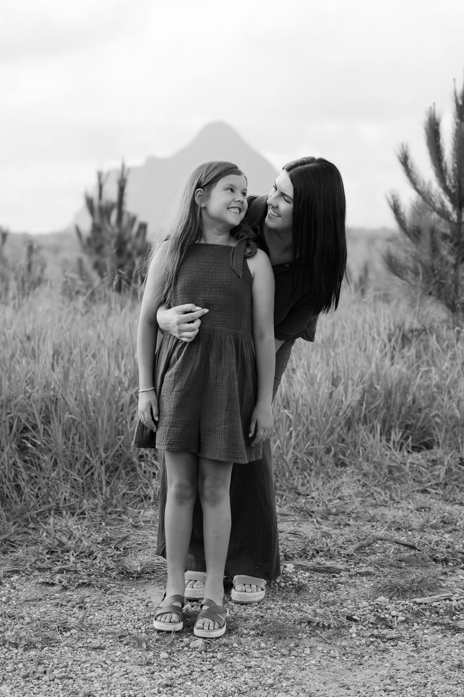 Brisbane maternity photographer — couple sharing a tender forehead kiss outdoors, expectant mother in blue dress, emotive maternity session
