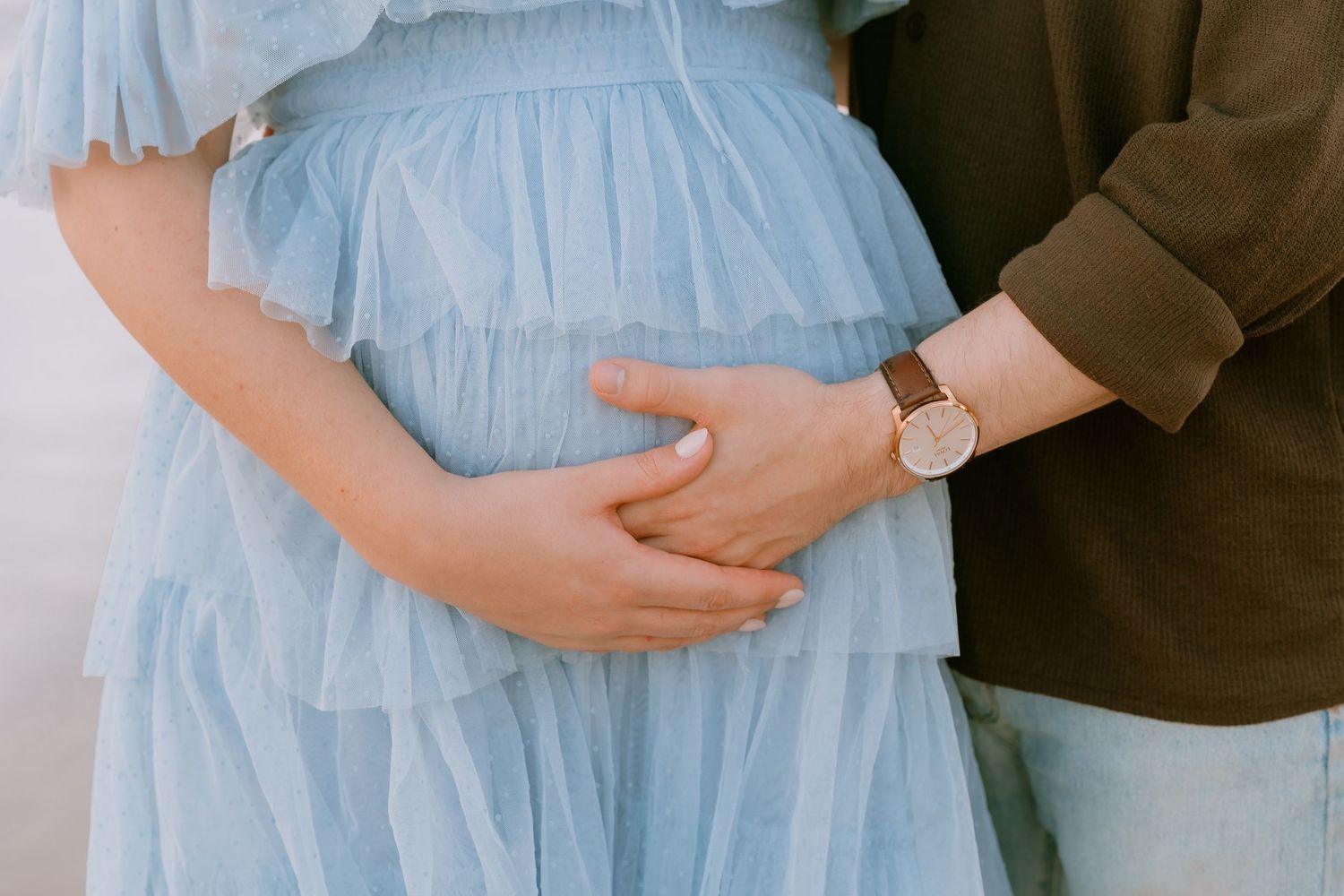 Brisbane maternity photographer — partner gently holding expectant mother from behind outdoors, tender and loving maternity session by Joy F