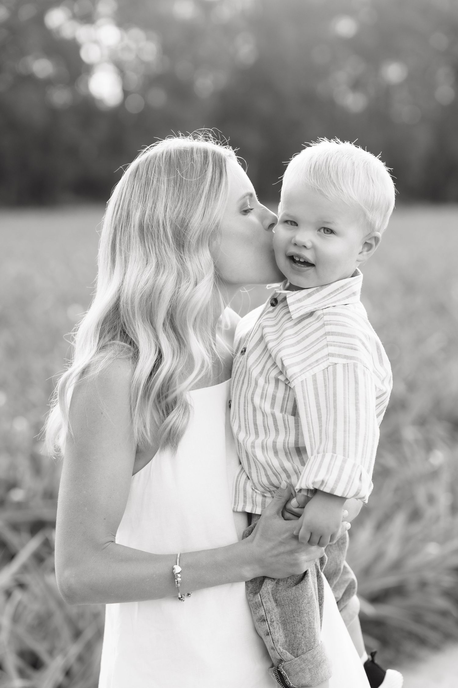 Brisbane newborn photographer — black and white portrait of mother tenderly holding her newborn baby, intimate in-home lifestyle session by