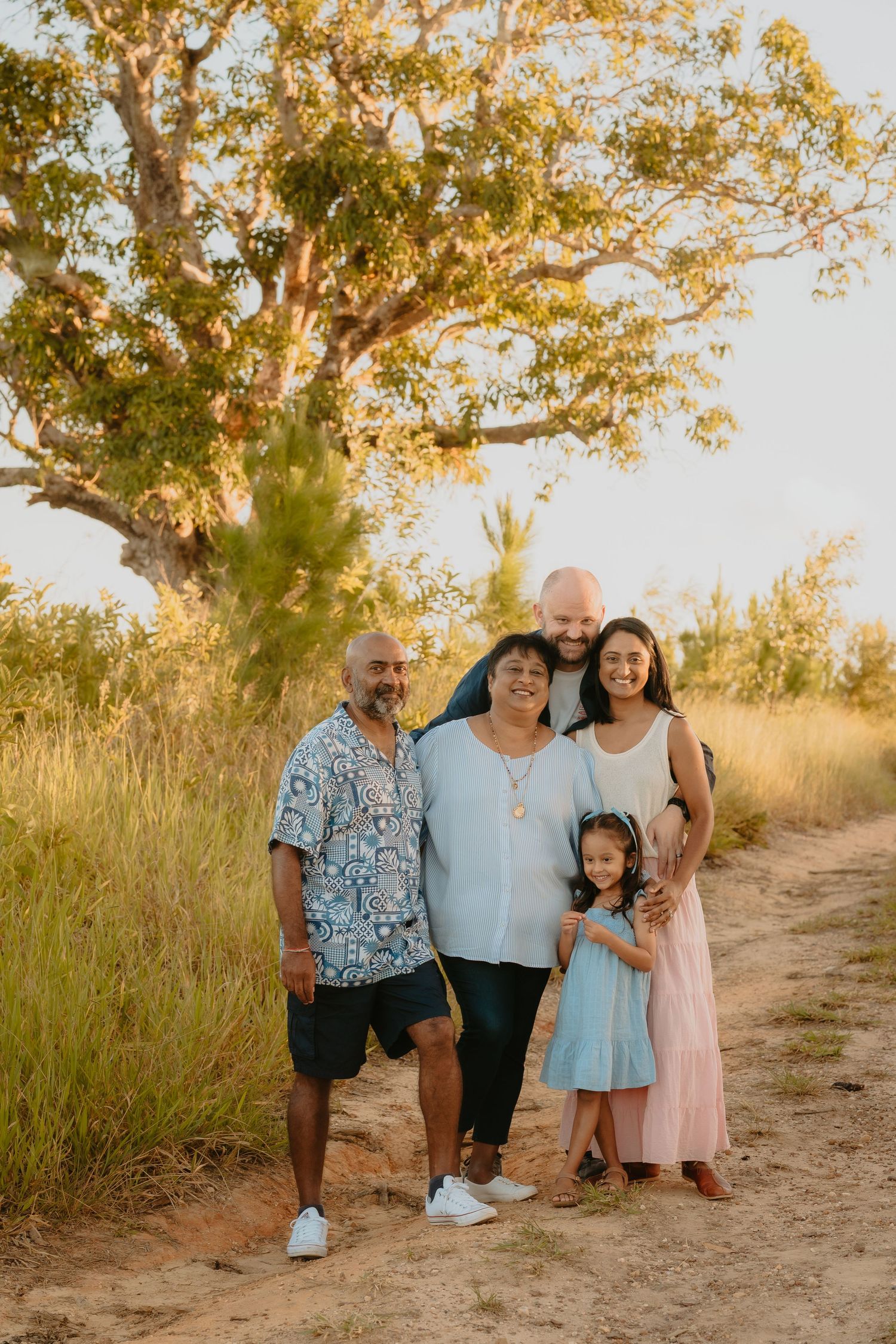 Brisbane family photographer — family with young children walking through golden hour outdoor field, warm and candid lifestyle session by Jo