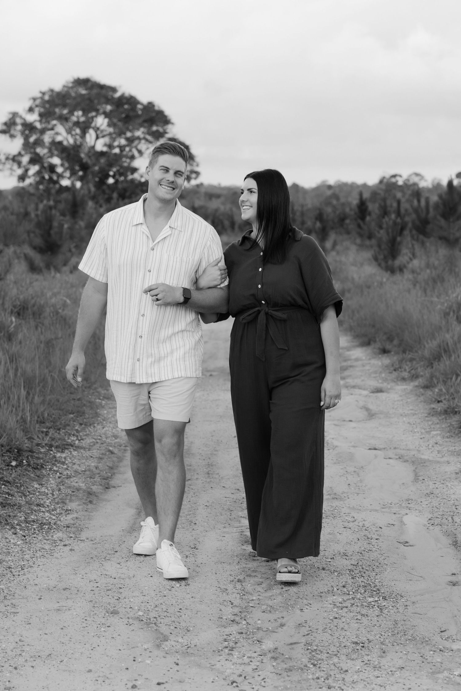 Brisbane wedding photographer — black and white portrait of couple walking together through nature, relaxed and candid wedding day portrait