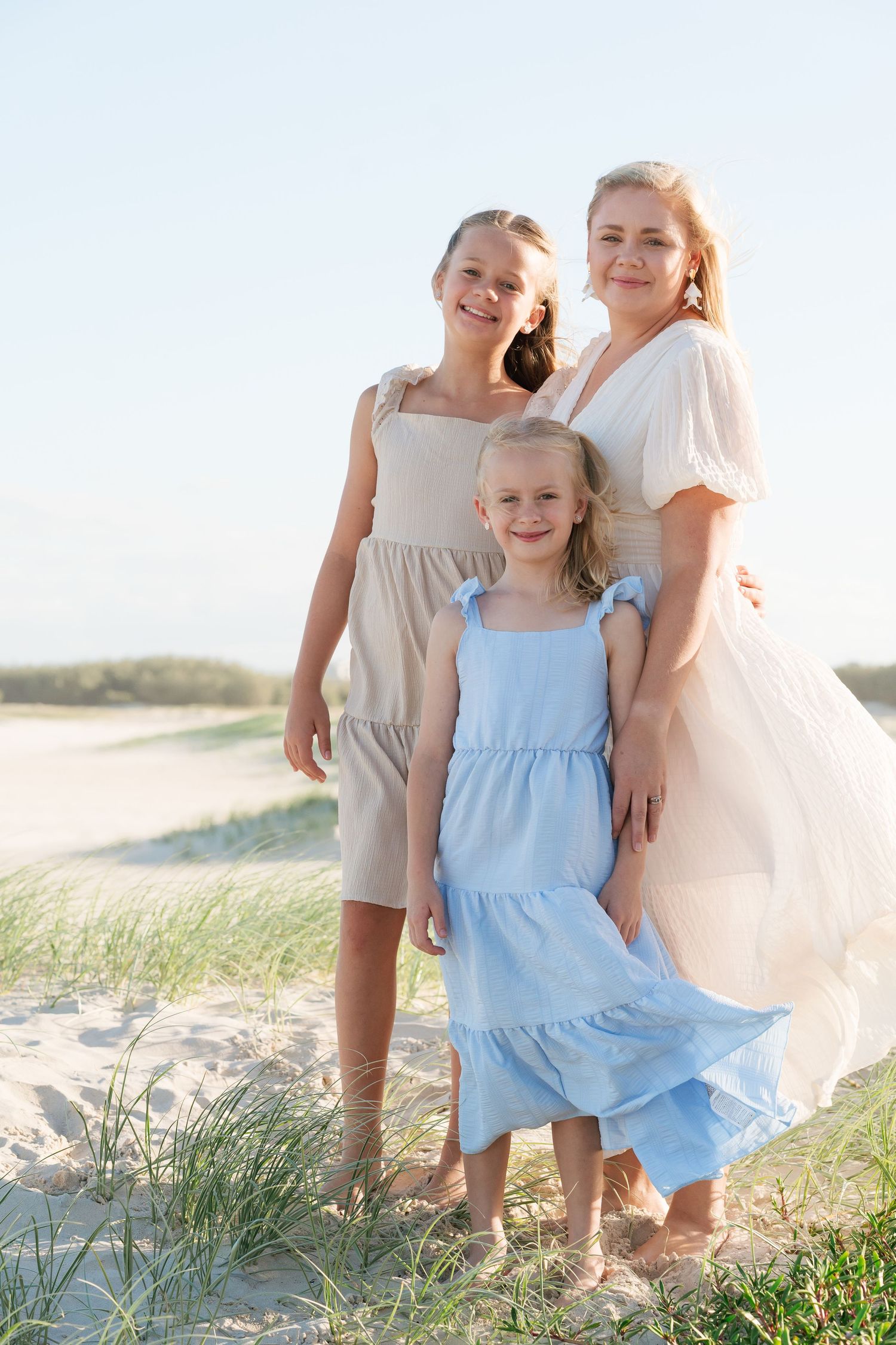 Brisbane family photographer — mother and two daughters standing together at sunny beach location, Brisbane Northside family session by Joy