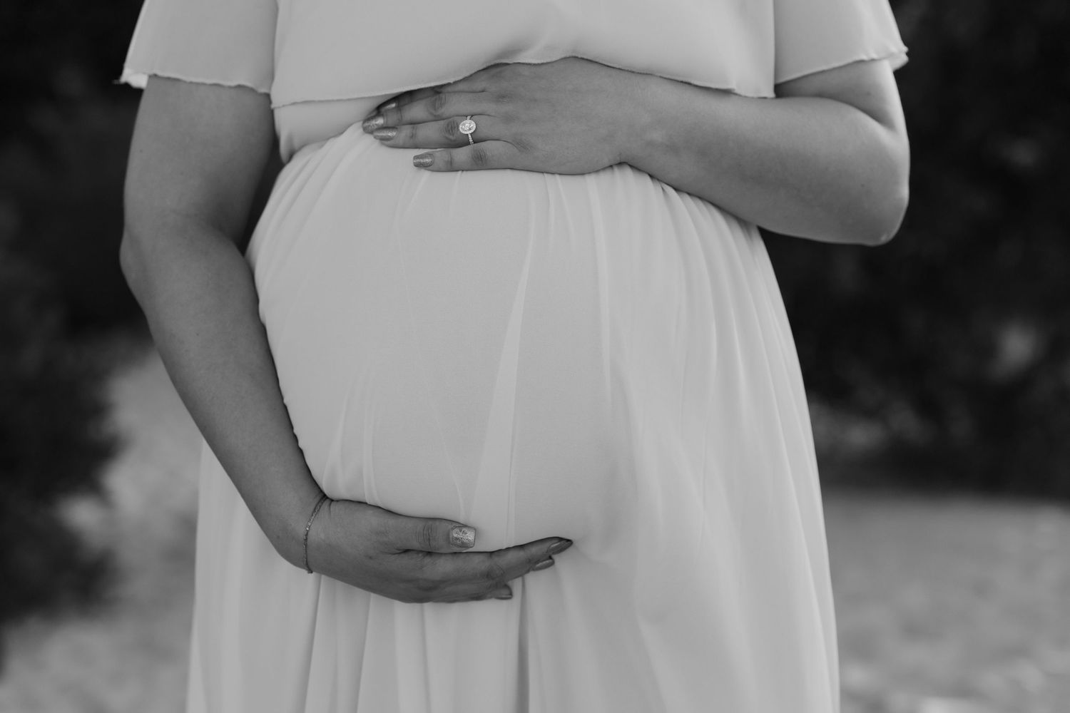 Brisbane newborn photographer — black and white close-up of sleeping newborn in parent's arms, serene and intimate in-home lifestyle session