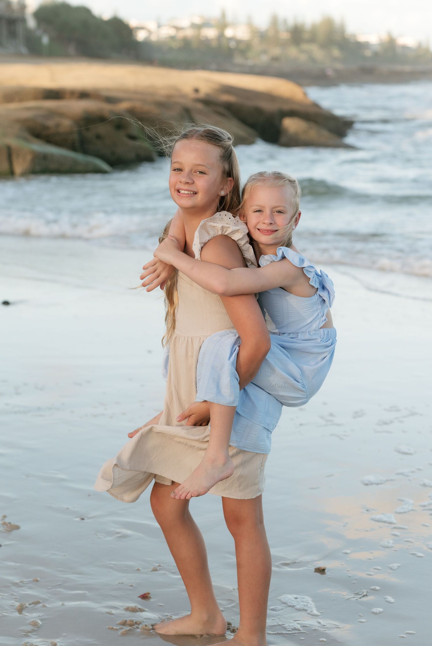 Brisbane family photographer — mother lifting and hugging young child on the beach, candid golden hour moment by Joy Filled Photography