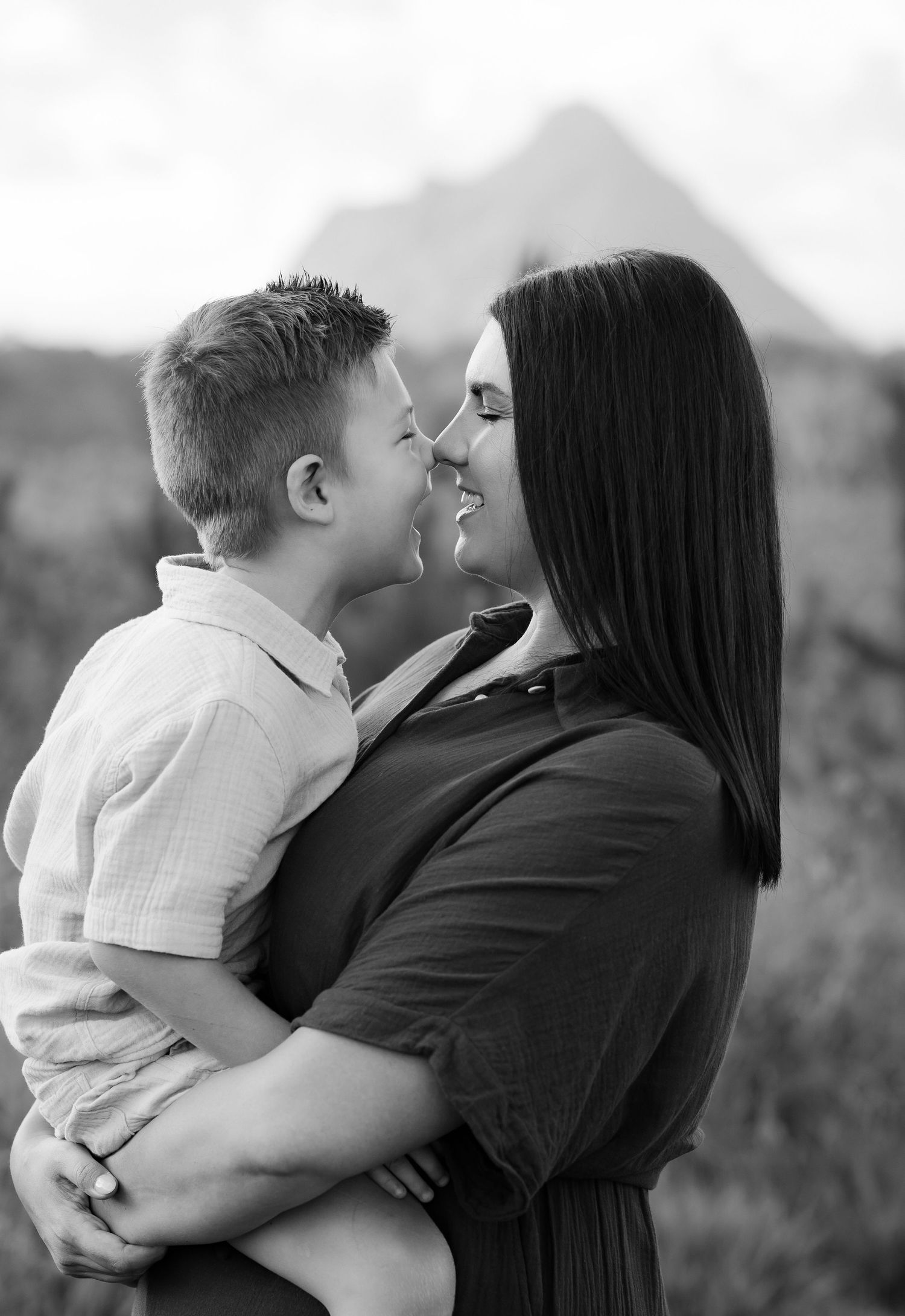 Brisbane maternity photographer — partner gently holding expectant mother's bump from behind, intimate and loving outdoor maternity session