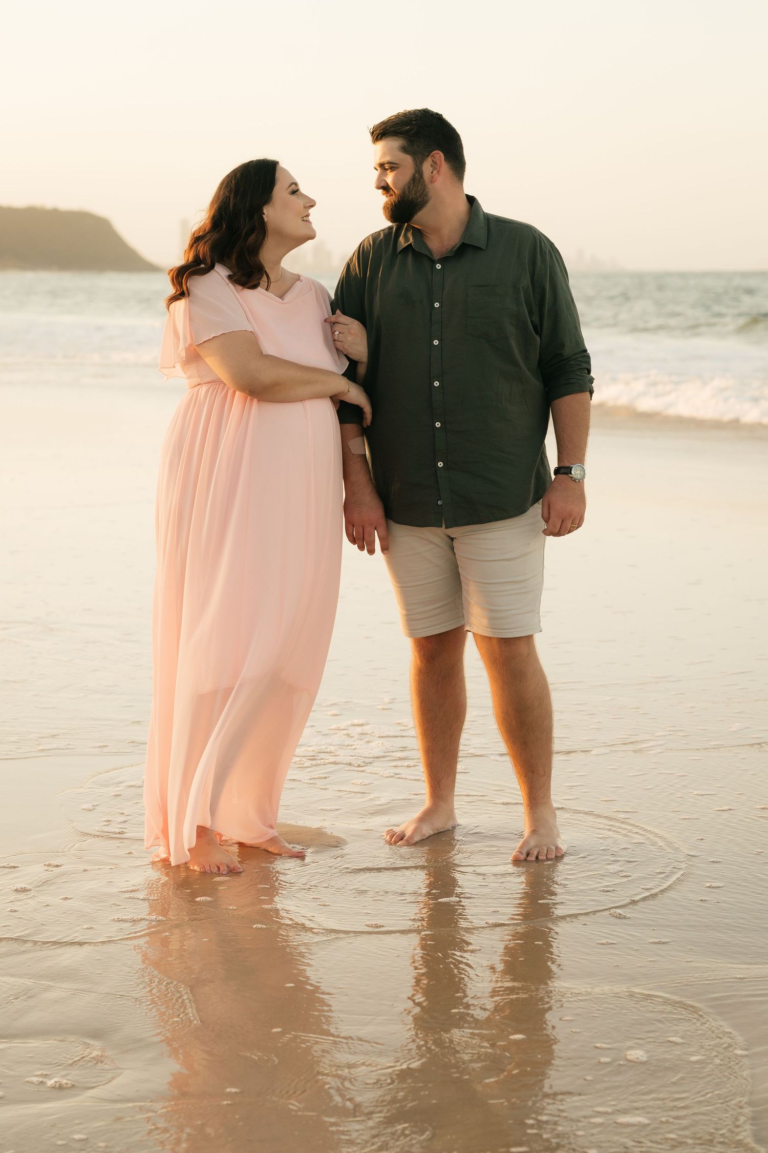 Brisbane maternity photographer — couple standing together on a beach at golden hour during outdoor maternity session by Joy Filled Photogra