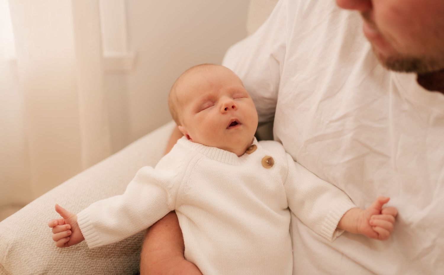 Brisbane newborn photographer — peaceful newborn baby lying on parent's hands, warm natural light in-home session by Joy Filled Photography