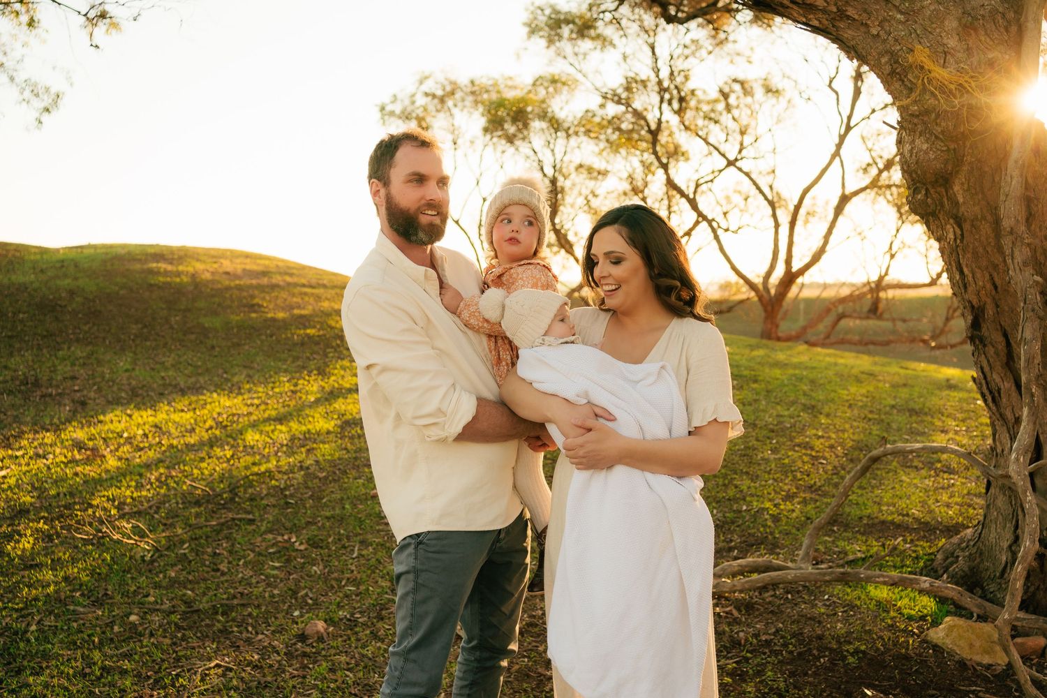 Brisbane family and newborn photographer — couple with newborn baby in golden hour light under a tree, beautiful fresh 48 session by Joy Fil