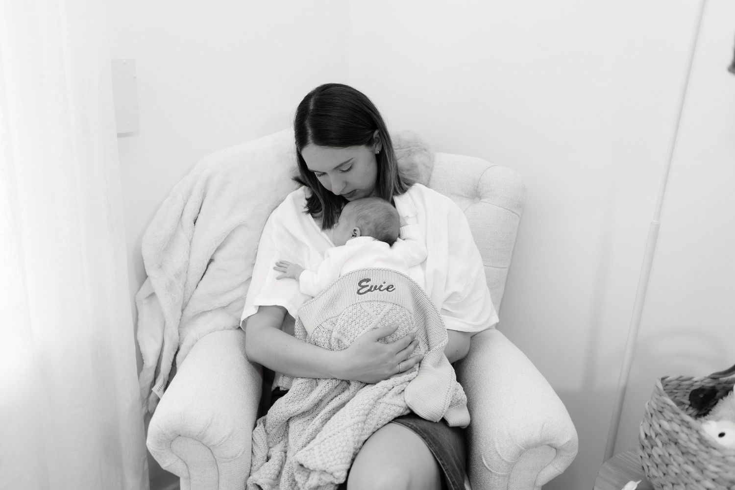 Brisbane newborn photographer — black and white mother cradling newborn baby during tender in-home newborn session, Joy Filled Photography N