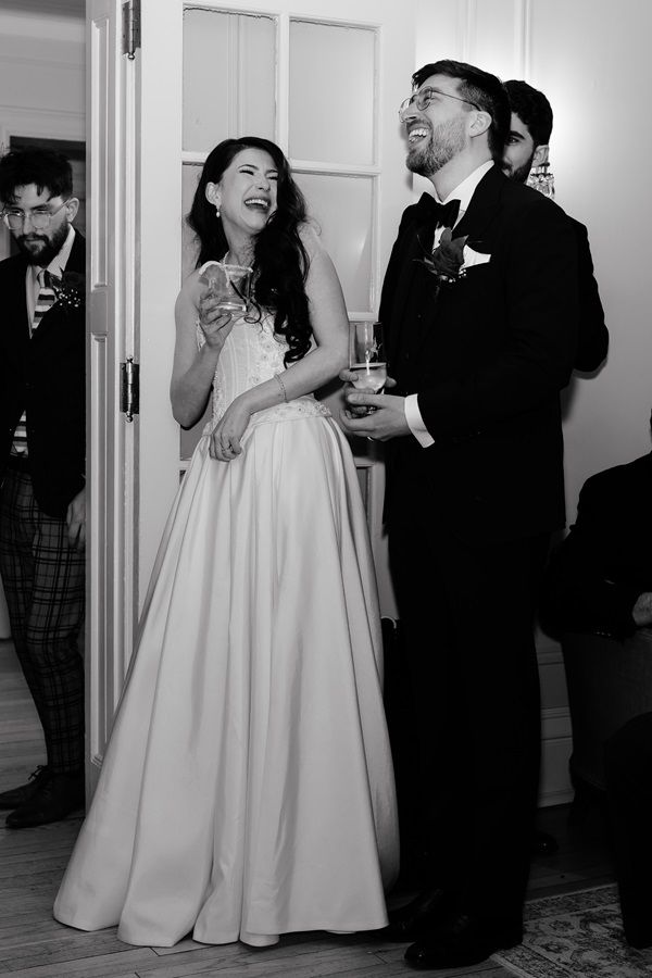 A joyful wedding moment captured in black and white as a couple shares laughter during their reception in Etobicoke.