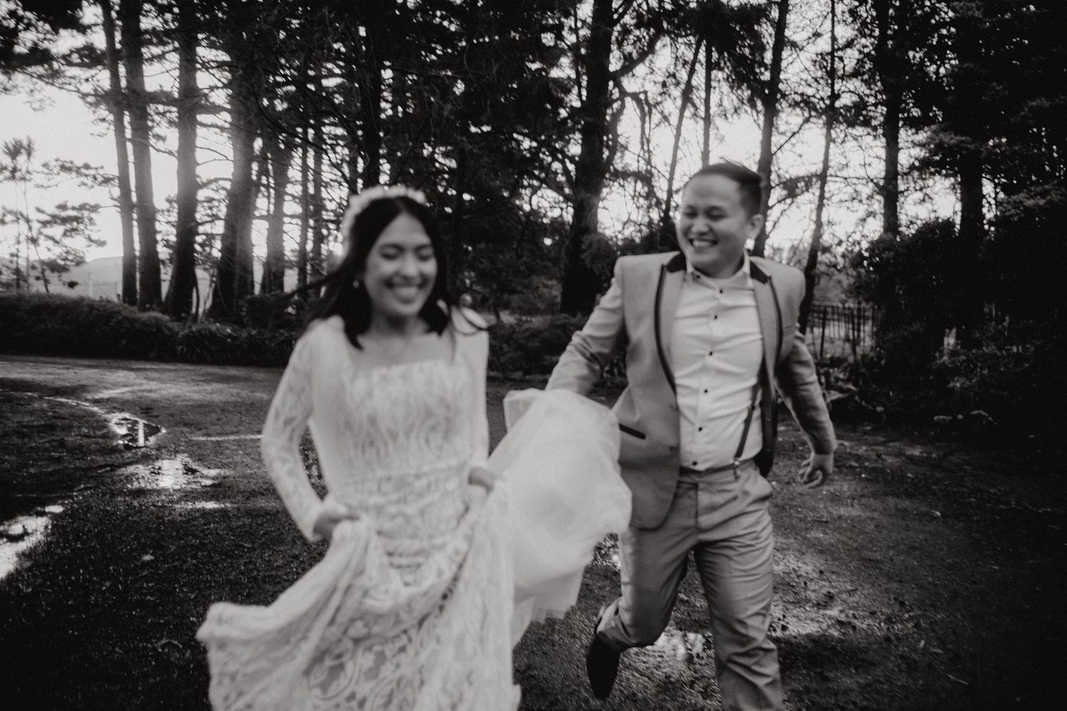 A couple shares a romantic moment in a sunlit forest during their wedding photoshoot.