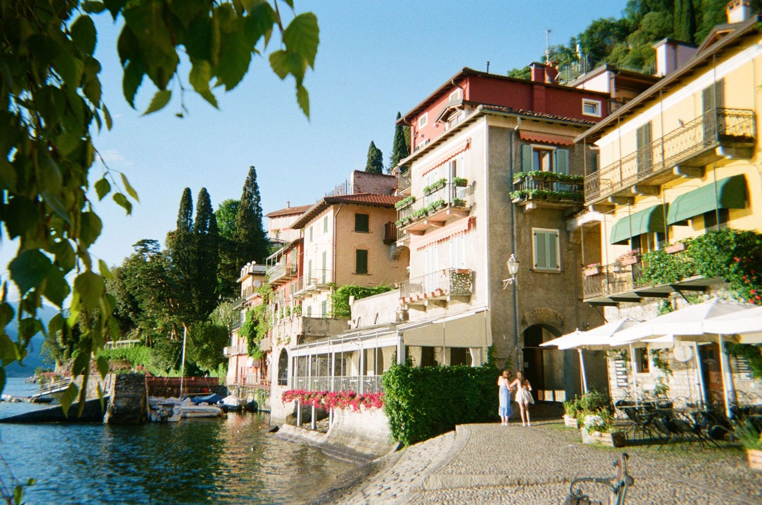 Colorful Italian lakeside village with charming buildings, outdoor cafes, and waterfront views.
